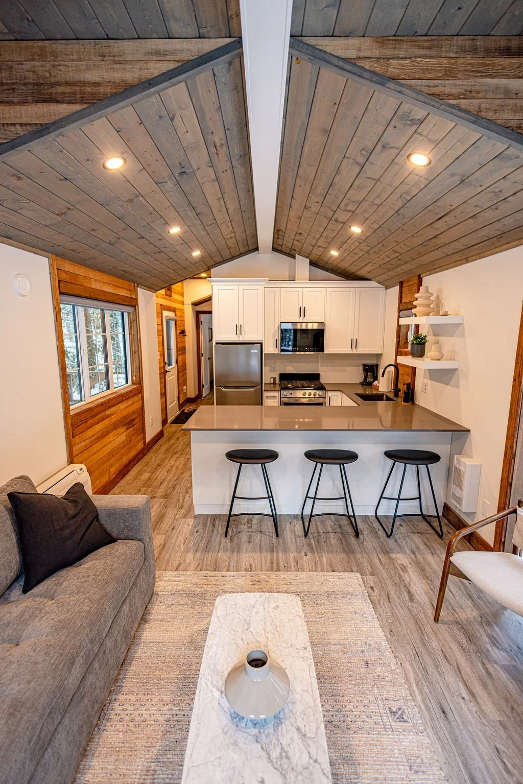 Elkhorn open living room and kitchen under a vaulted wood ceiling