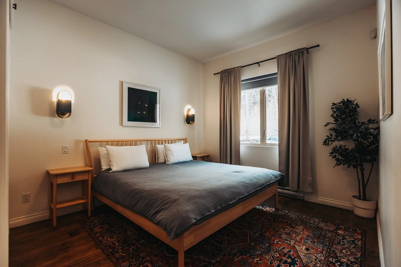 Hatchery suite bedroom with bedside lamps and a large window