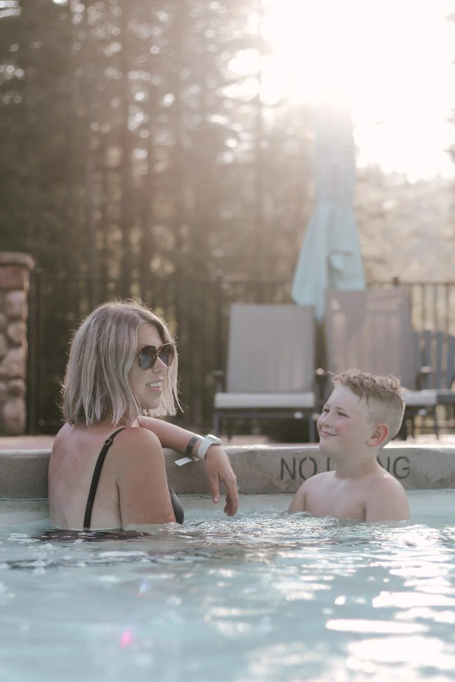 A mother and son soaking and talking in golden late-afternoon light
