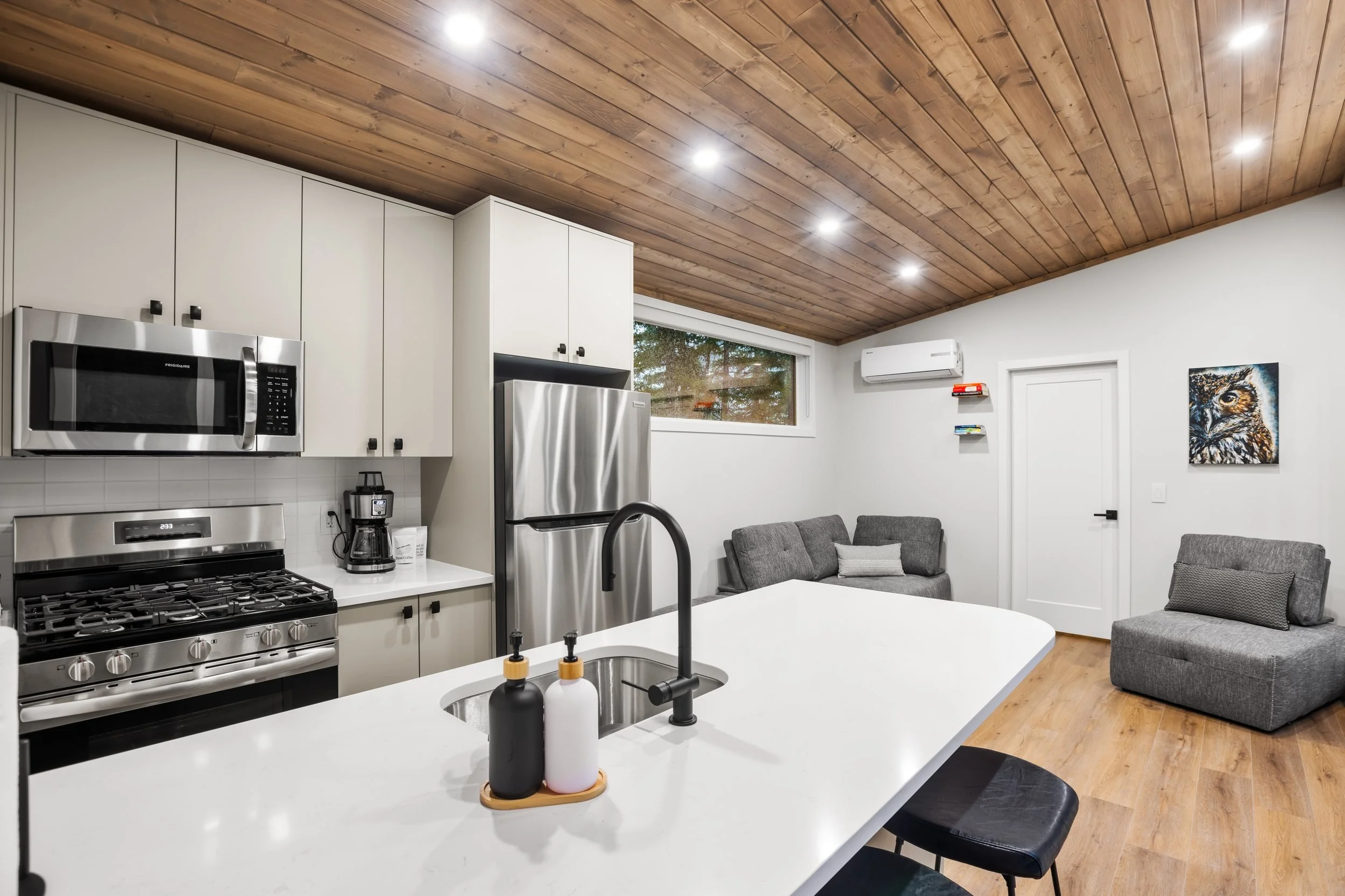 Shuswap kitchen with white cabinets, a gas range and an island