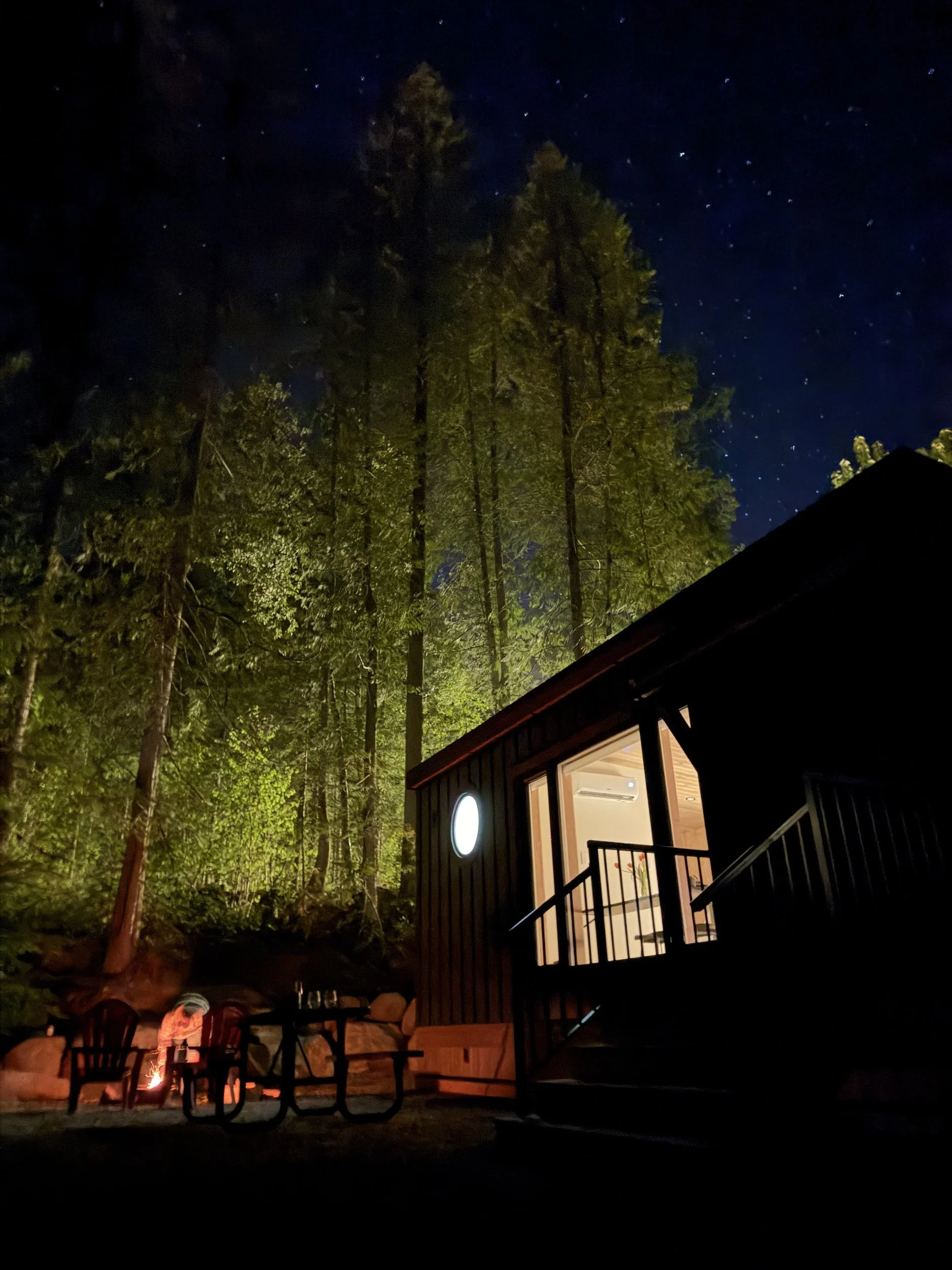 The Nest at night under a starry sky, with its outdoor fire pit glowing
