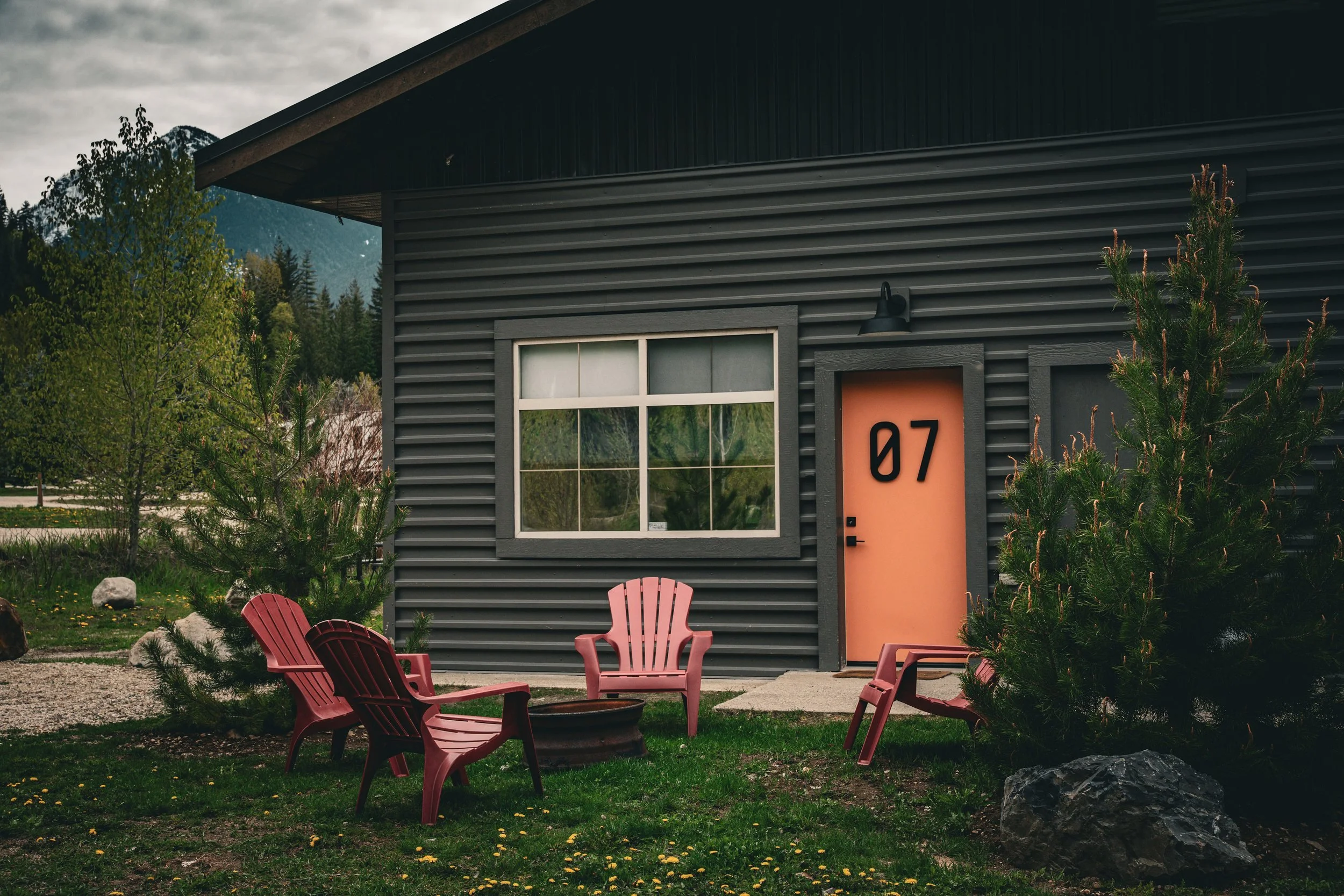 The Hatchery building, with suite doors and red Adirondack chairs on the lawn