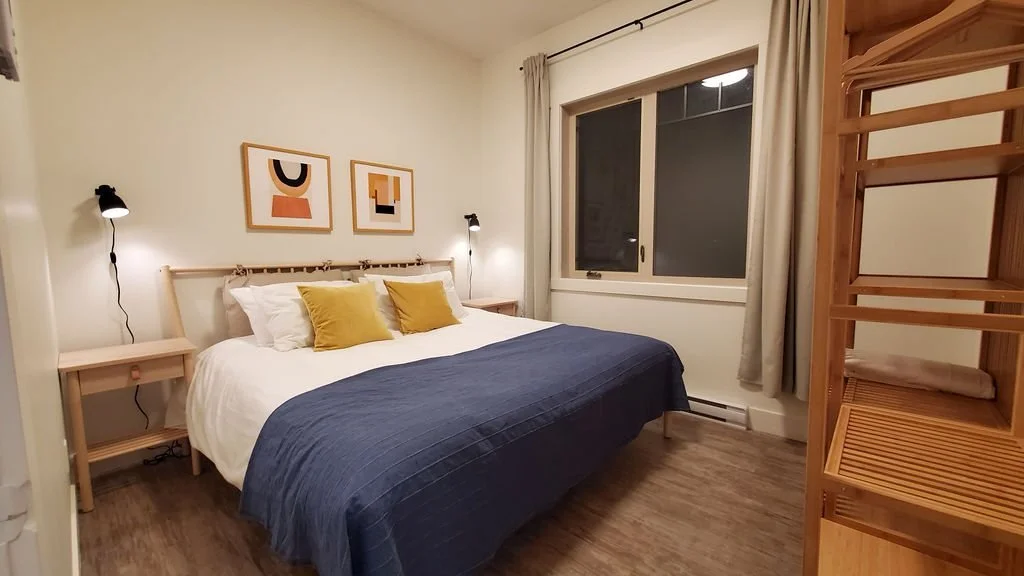 Second Hatchery suite bedroom with a navy duvet and a wooden ladder