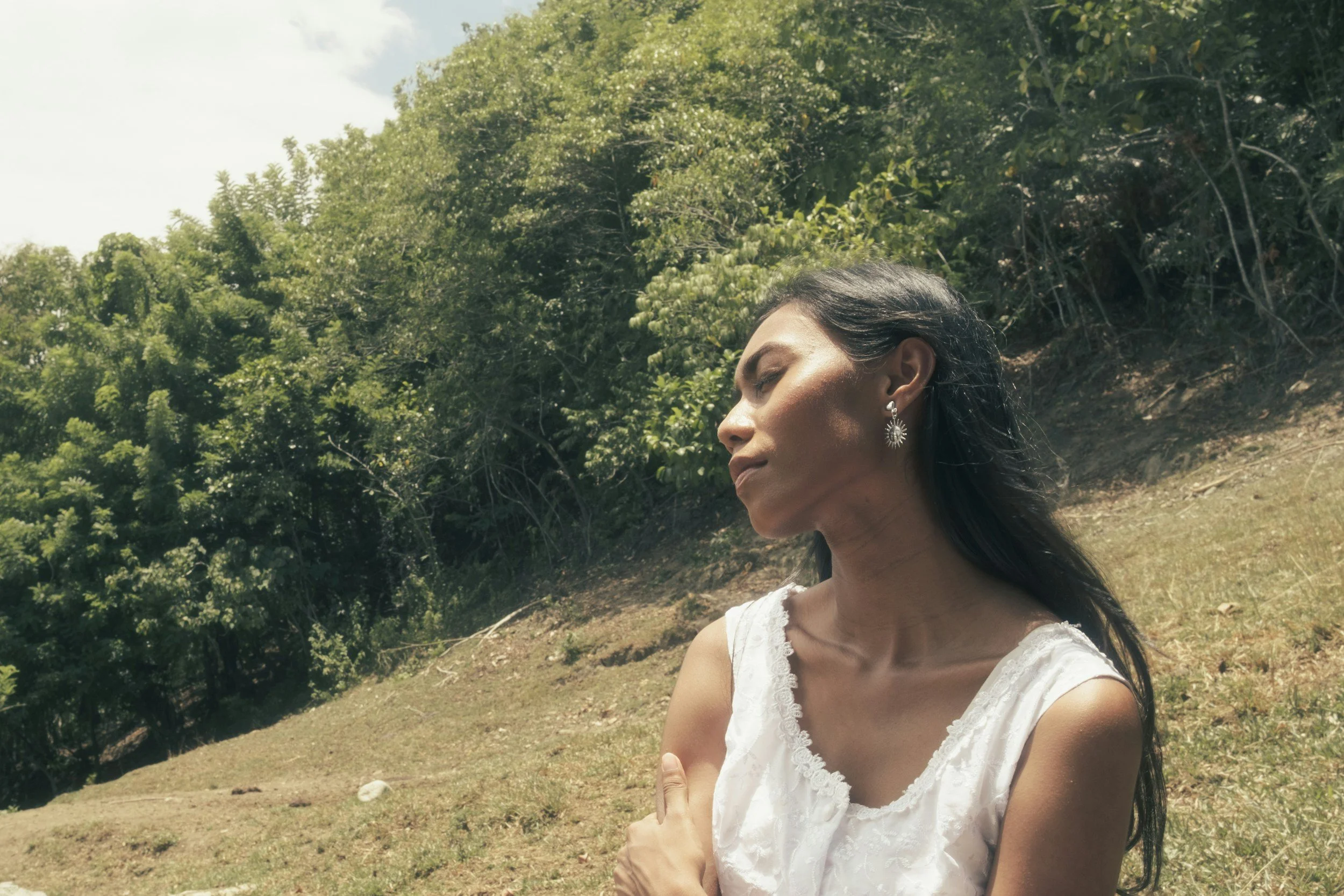 Woman taking a slow, grounding breath outdoors to ease anxious feelings about her herpes diagnosis