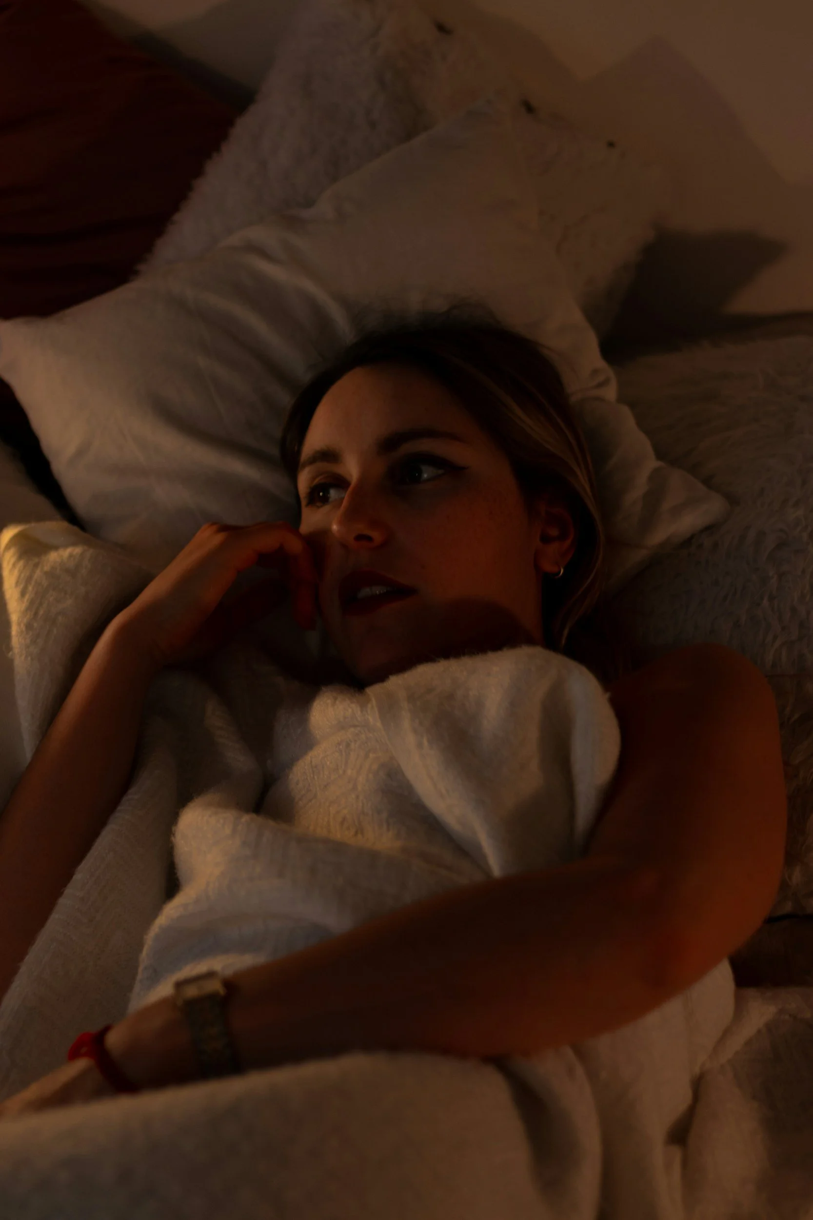 A person lying awake, unable to stop replaying conversations in their head