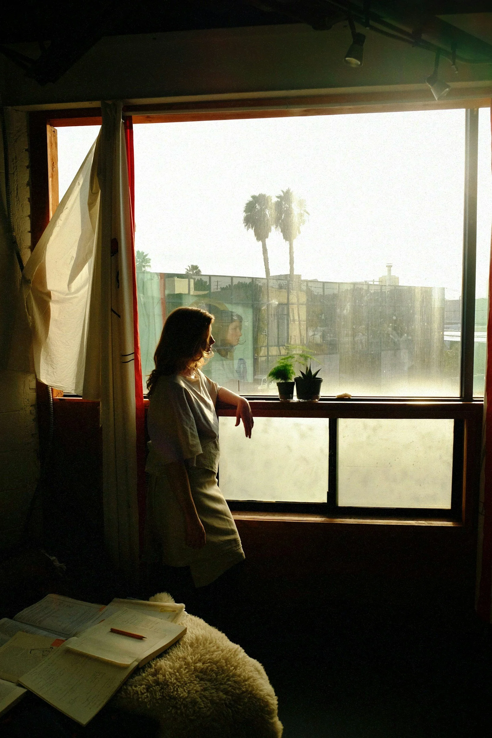 A person sitting quietly by a window, lost in thought and replaying a moment in their mind.