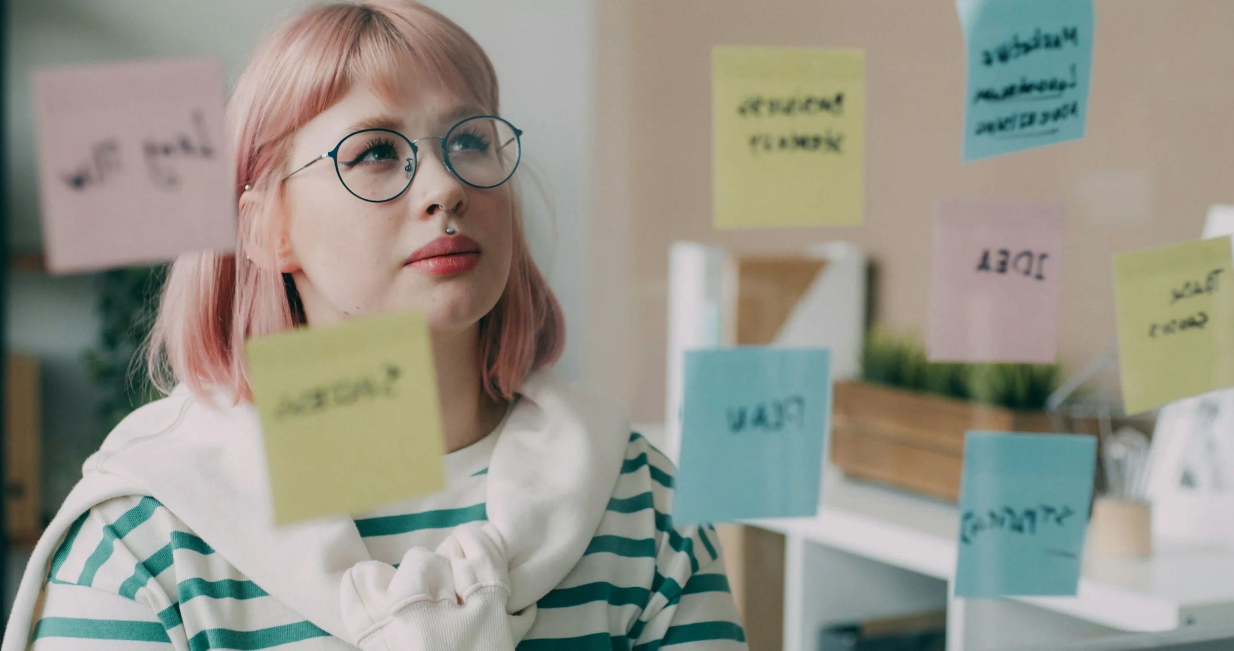 An adult is reviewing sticky notes, capturing the everyday overwhelm of living with undiagnosed ADHD.