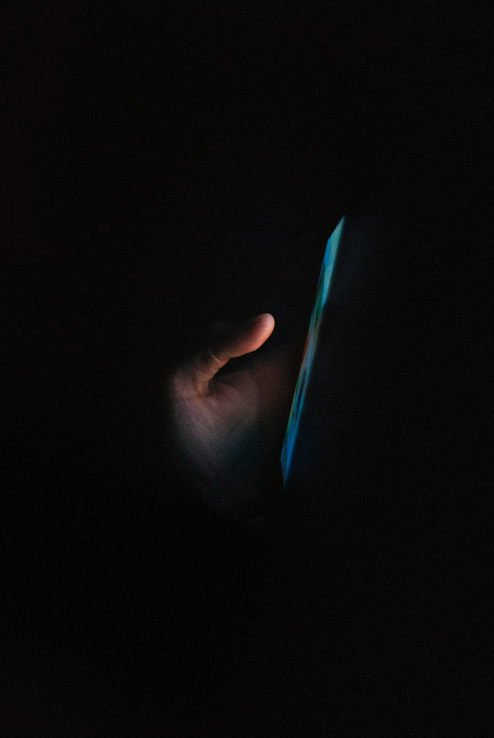 Person lit by phone glow in a dark room, caught in the doomscrolling loop