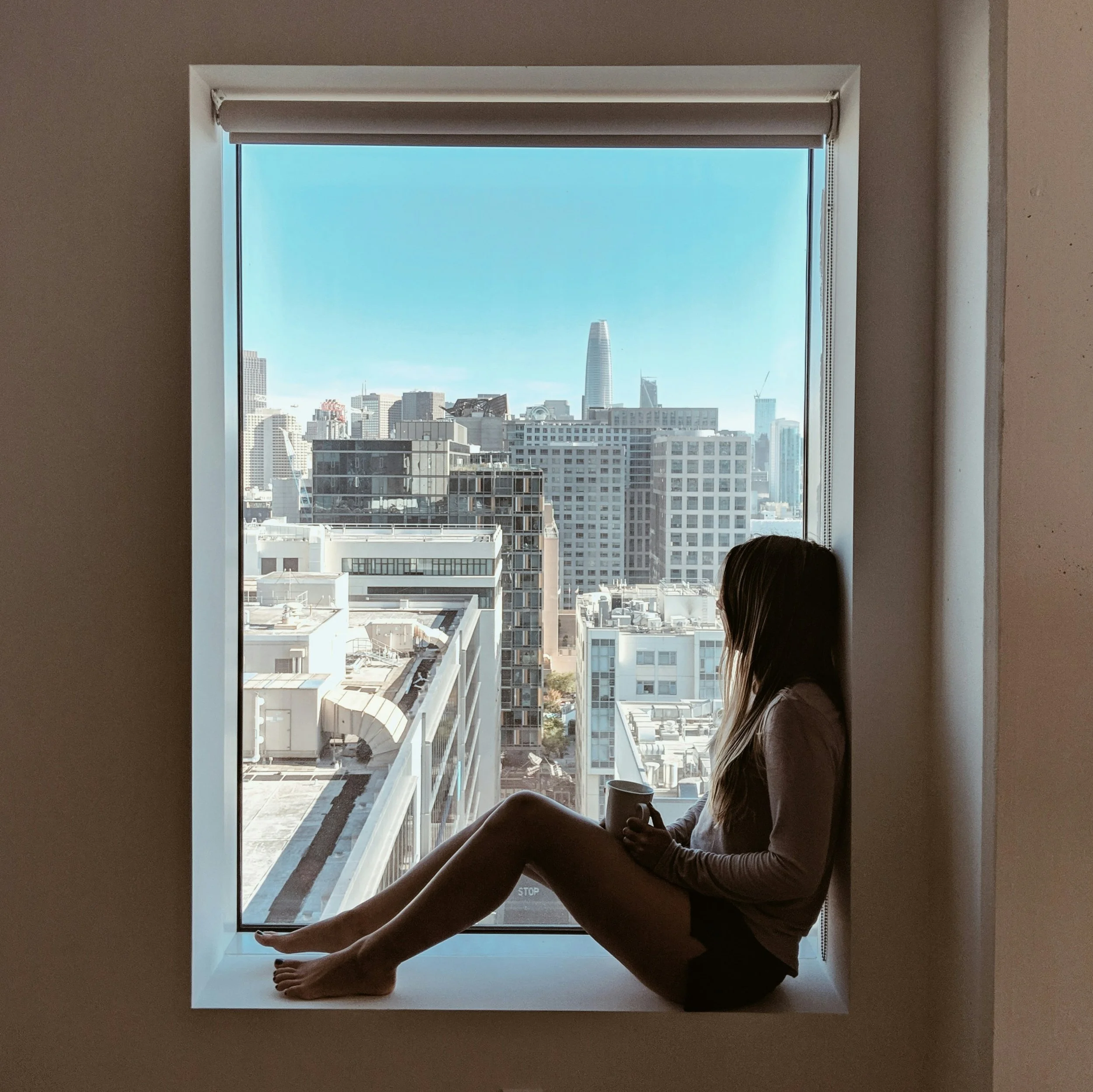 Person looking out a bright window in thought, wondering if this relationship healthy