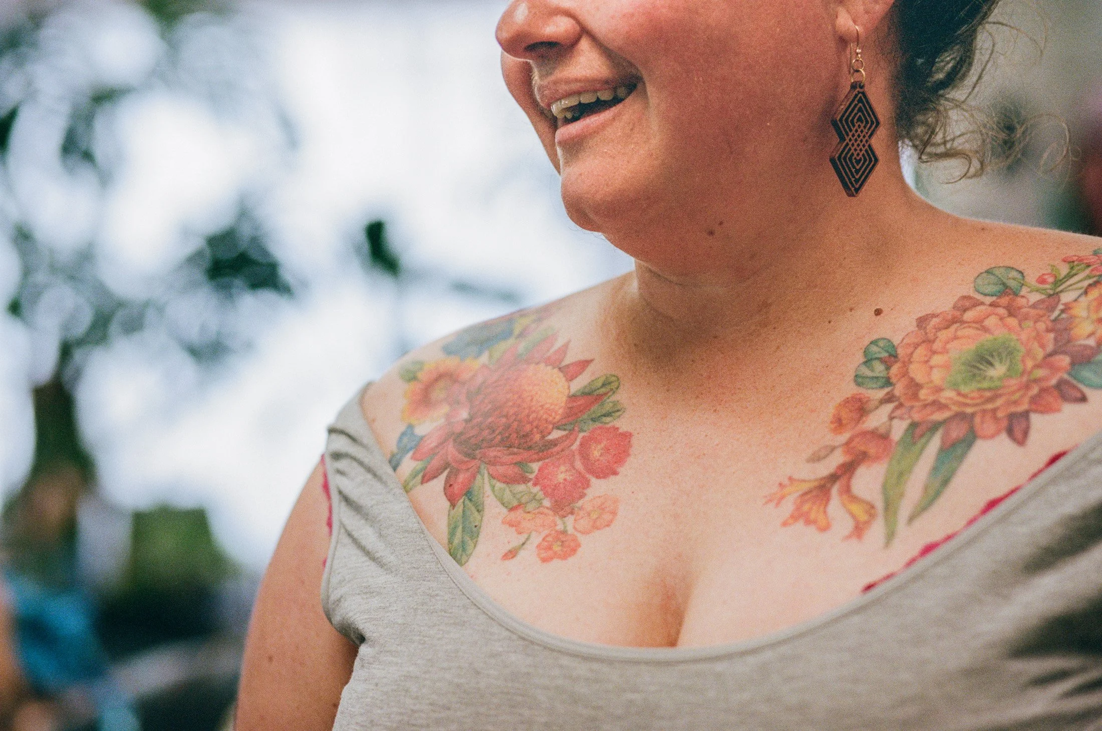 Natural portrait of a tattoo client featuring colourful tattoos and relaxed candid expression.