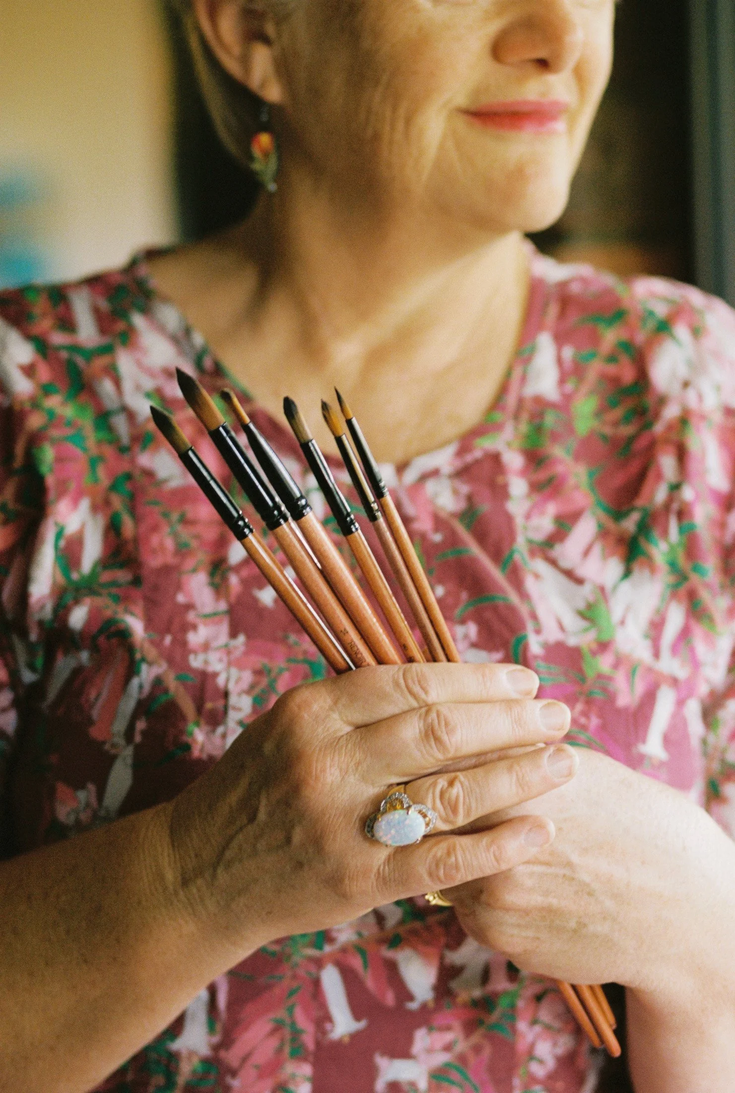 Close portrait detail of an artist holding paintbrushes during a creative portrait and studio documentation session. Mornington Peninsula