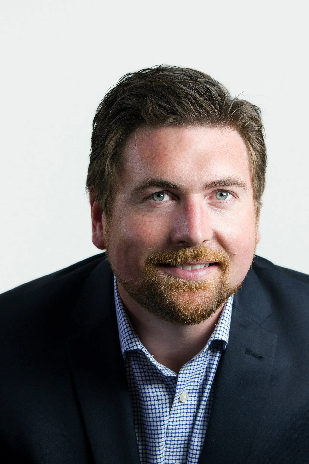 Polished corporate headshot of a man with a white background by Natalie Finney Photography