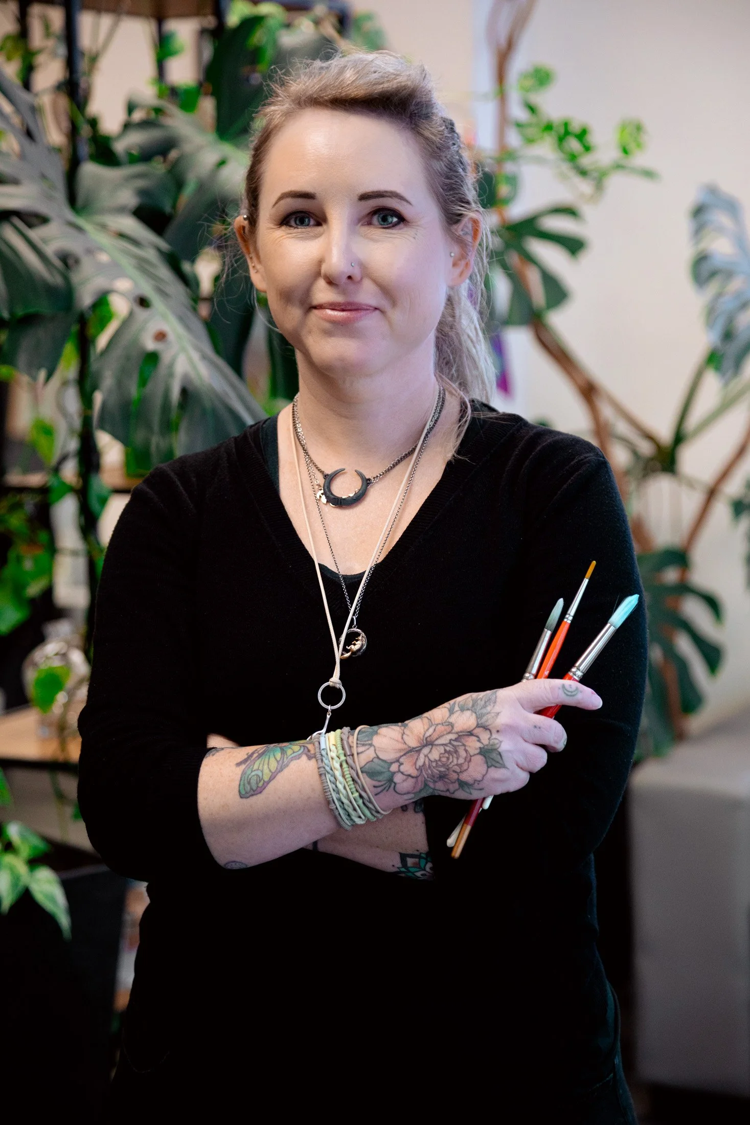 Portrait of Melbourne artist holding paintbrushes inside her creative studio during a Maker Series portrait session.