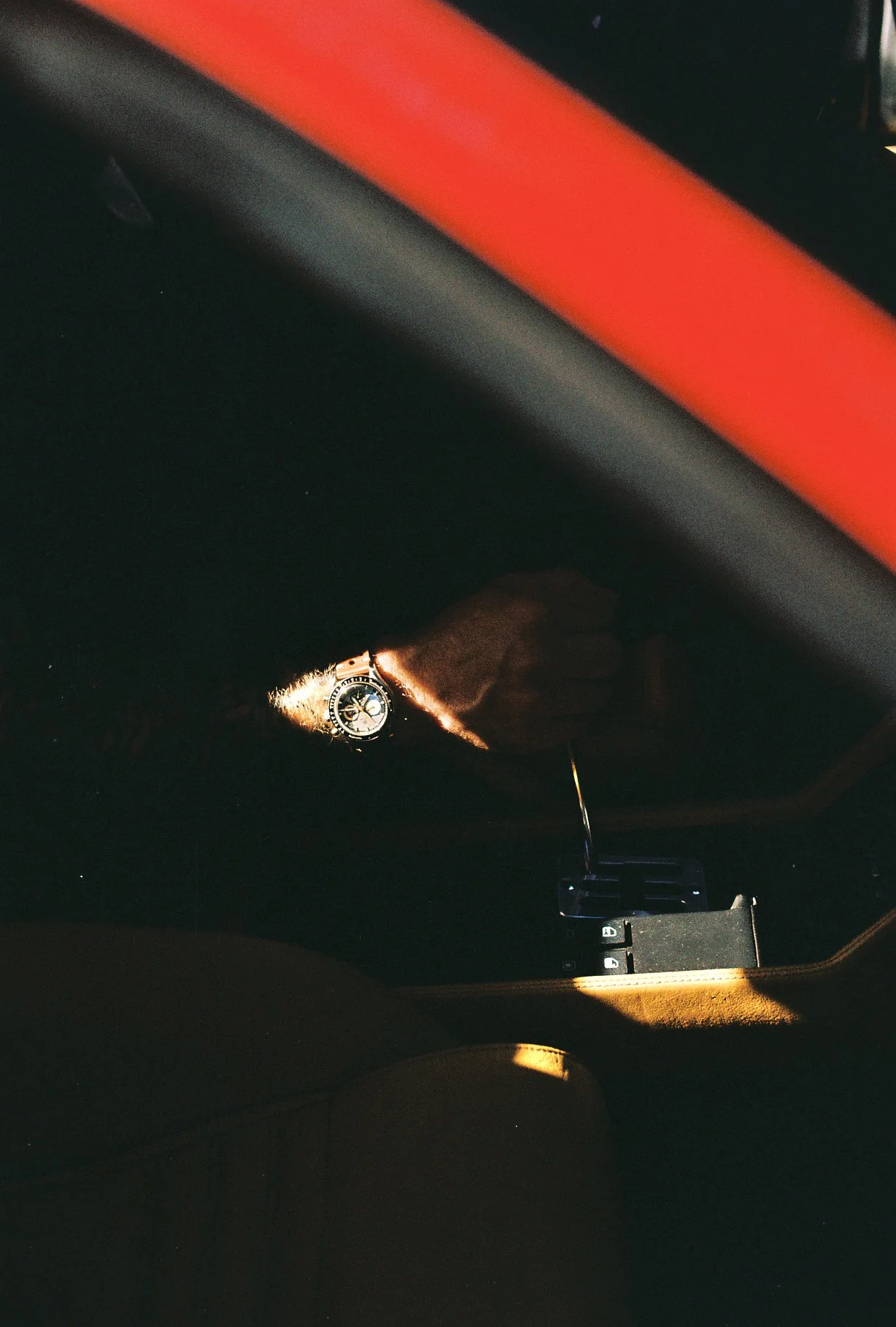 Nezumi Voiture VM2 on a wrist inside the Ferrari 348, caught in sunlight in a Nikomat film photograph.