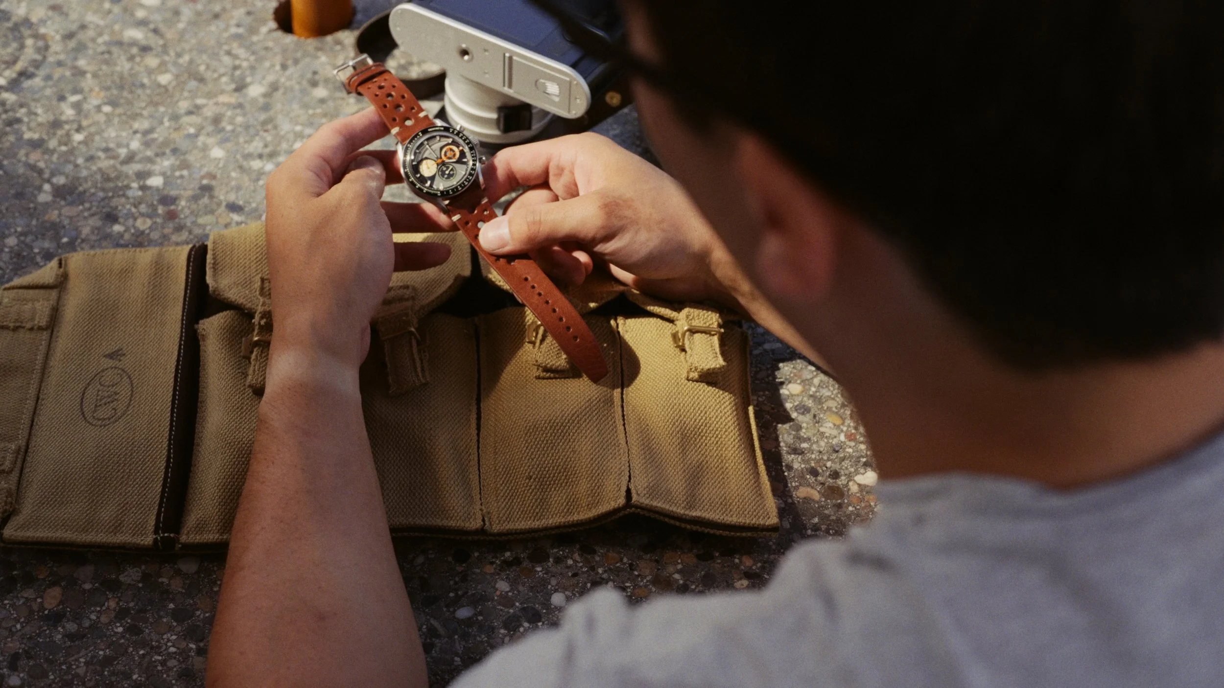 Video frame of Julian examining the Nezumi Voiture VM2 over a watch roll at an outdoor table.