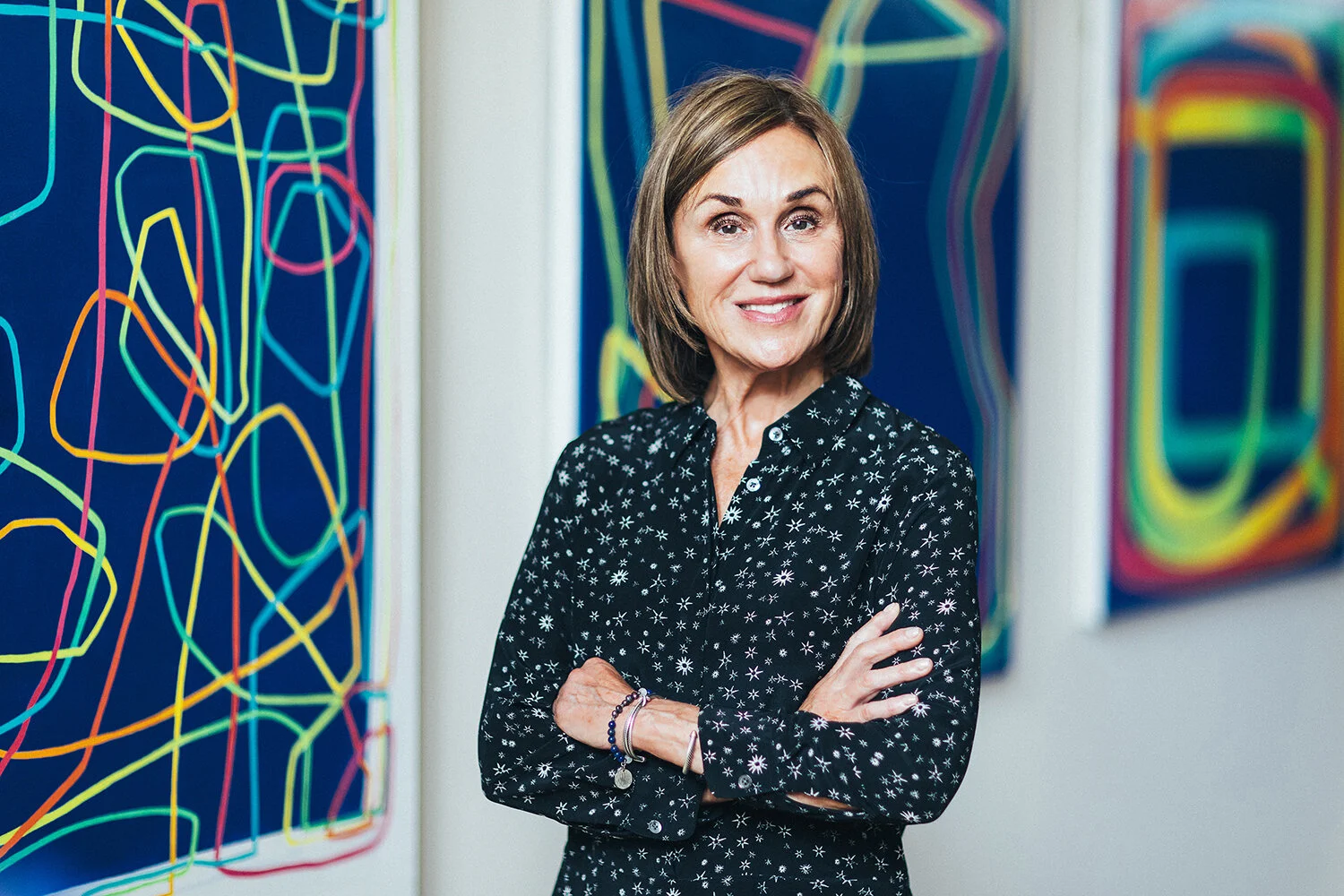 Portrait of contemporary artist Paula Cahill in her studio with abstract line paintings.