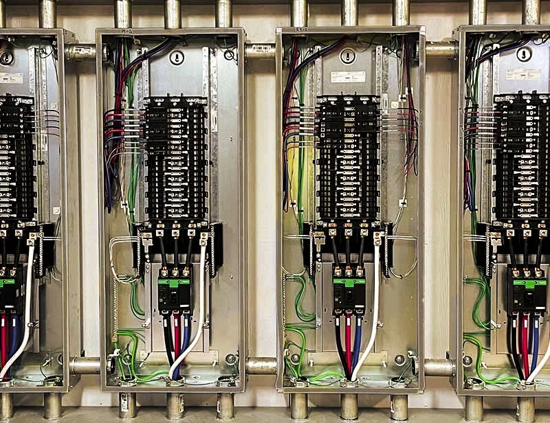 Upgraded commercial electrical room panels featuring clean wiring and increased capacity for future expansion loads.