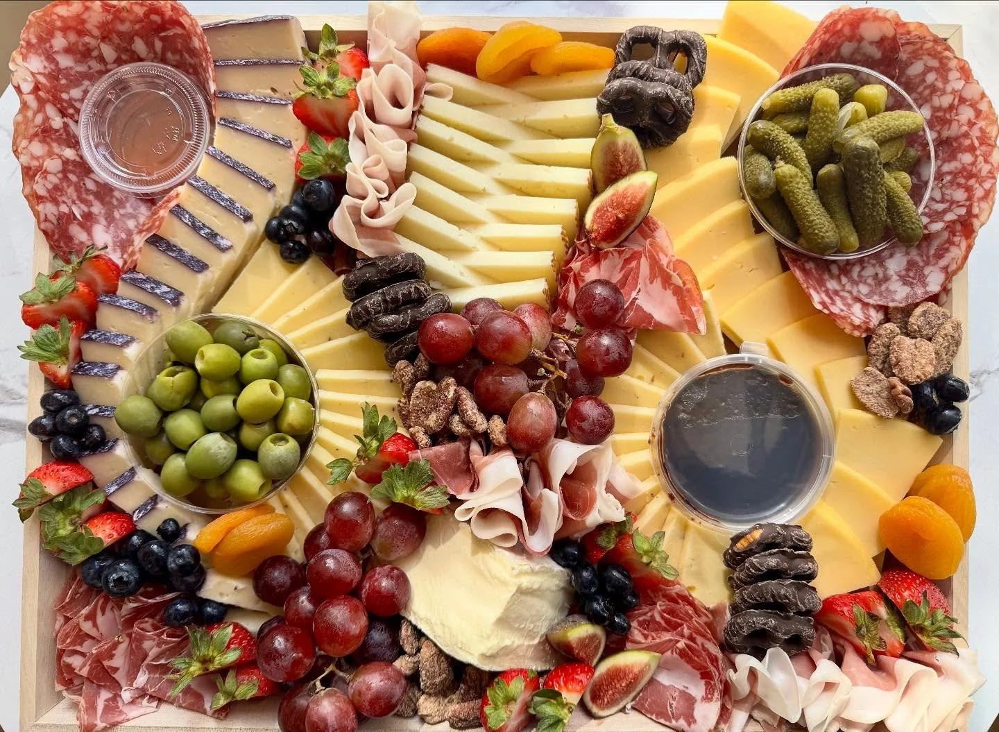 Large Charcuterie 🧀

🧀 Manchego, Double Cream Gouda, Wine Soaked Toscano, Triple Cream Brie, Truffle Gouda
🍖 Mild Capicola, Prosciutto, Rosette de Lyon Salami
🫒 Cornichons, Castelvetrano Olives
🍯 Blueberry Bourbon Pecan Jam &amp; Wildflower Hone