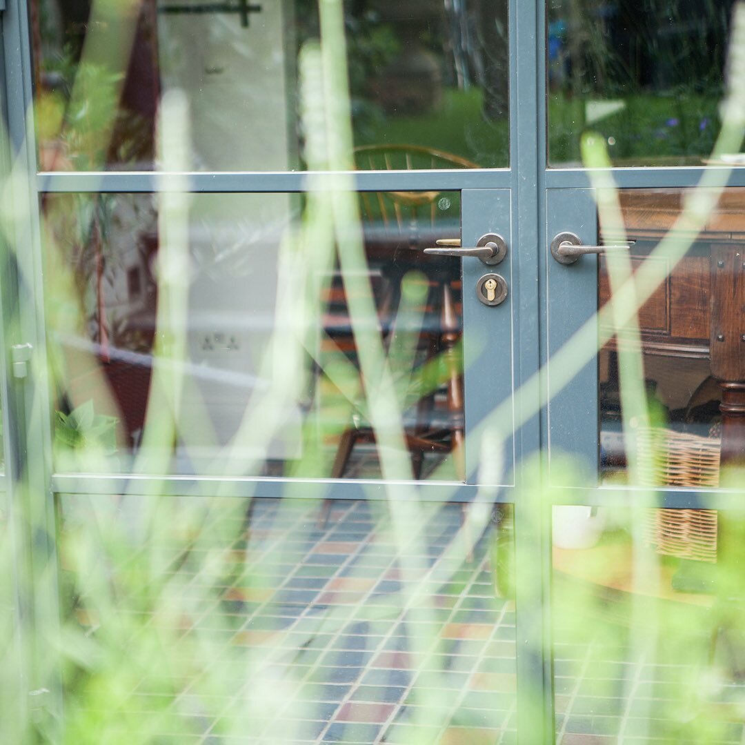 We just love the sight lines that come with Crittall doors. Framing the view to inside here at one of our projects in Barnes, you get a glimpse of the charming tiled floor.  #humbleandhumble