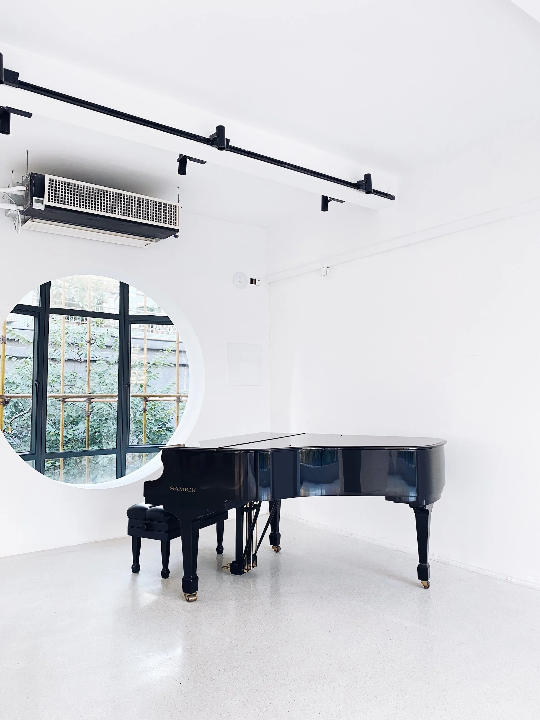 Grand piano in a white room with a vaulted ceiling.
