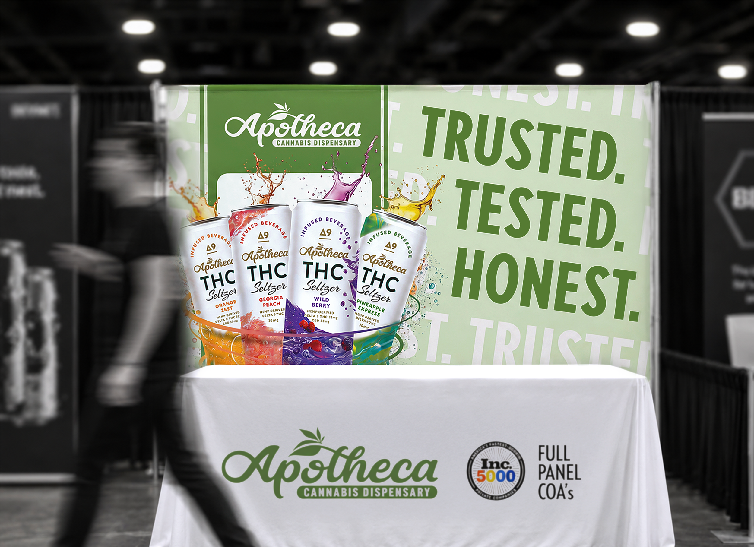 Apotheca cannabis dispensary trade show booth designed by Buzz & Bloom Media, featuring custom branded backdrop and table display with THC seltzer products.