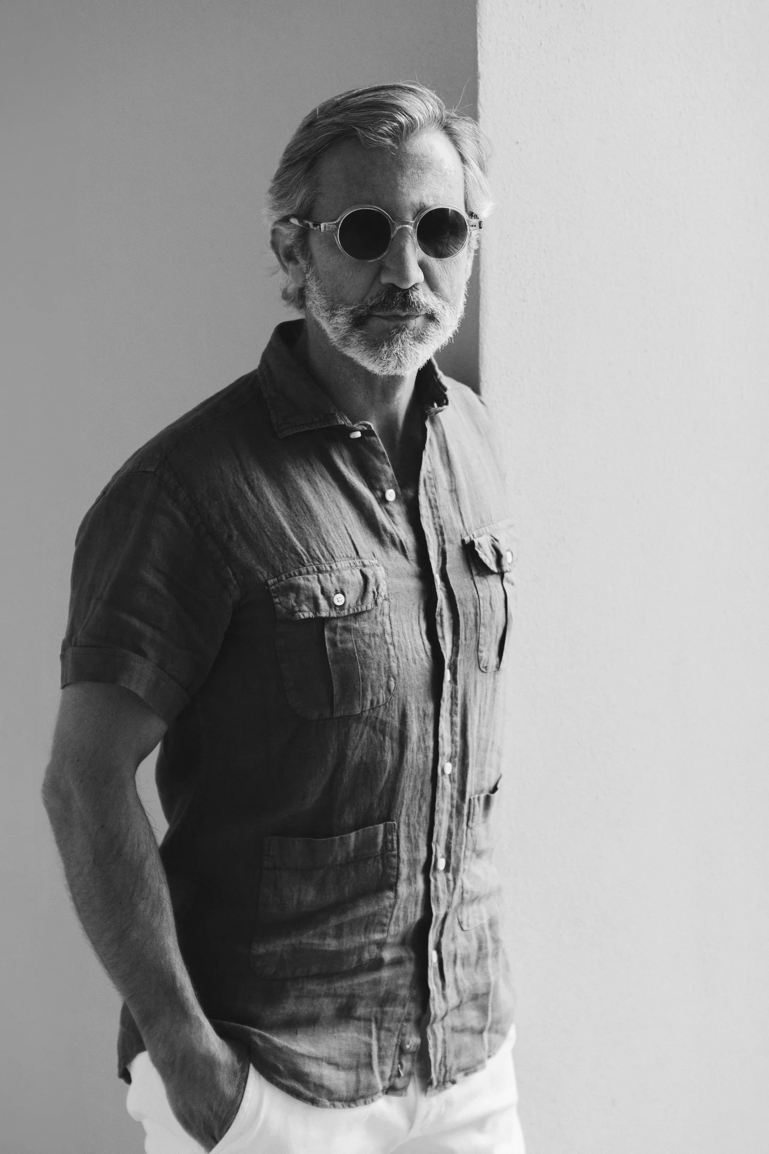 Retrato masculino en blanco y negro, de pie junto a una pared