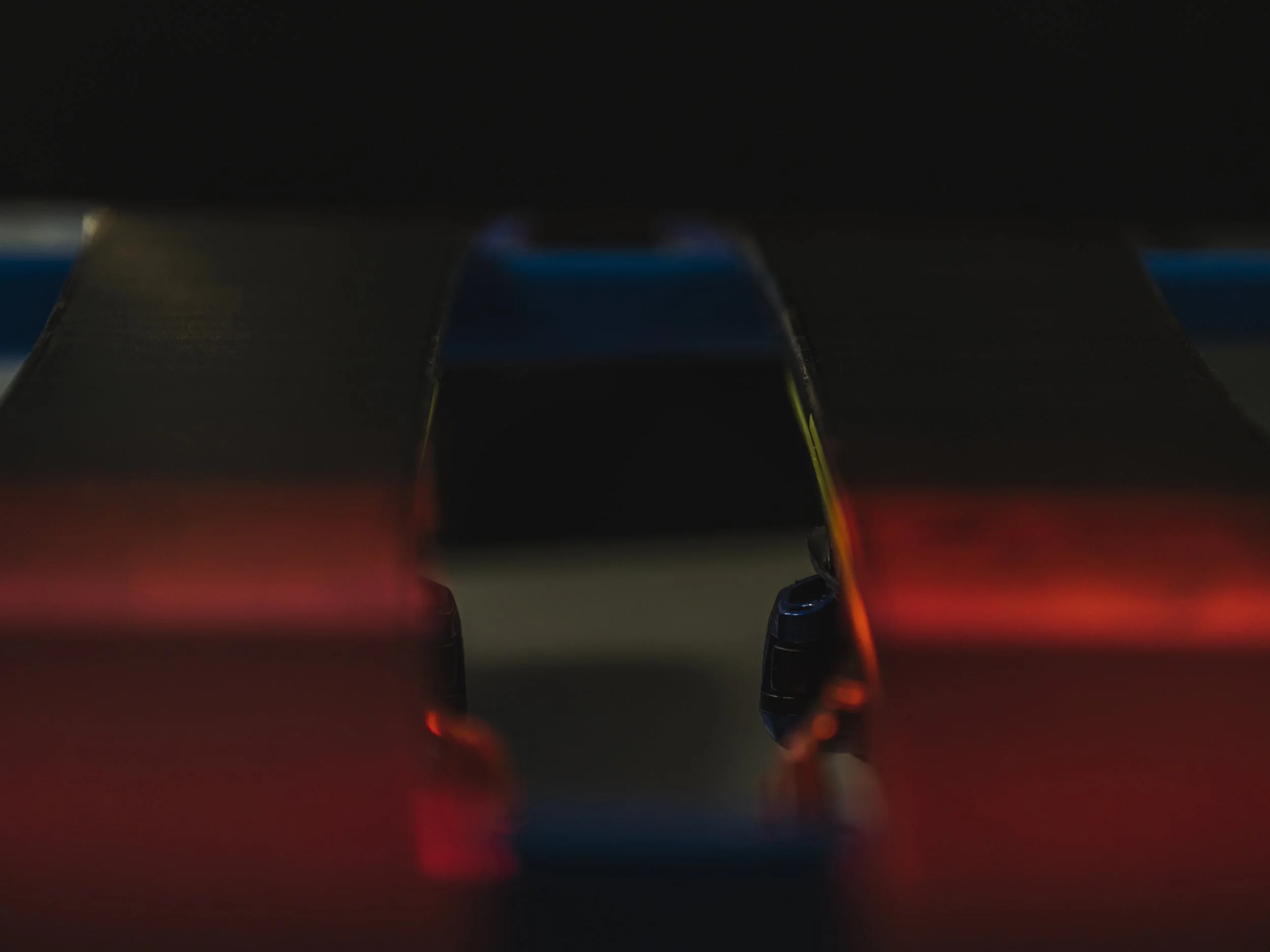 Una maqueta de un coche de carreras iluminado con luces rojas y azules en un entorno oscuro.