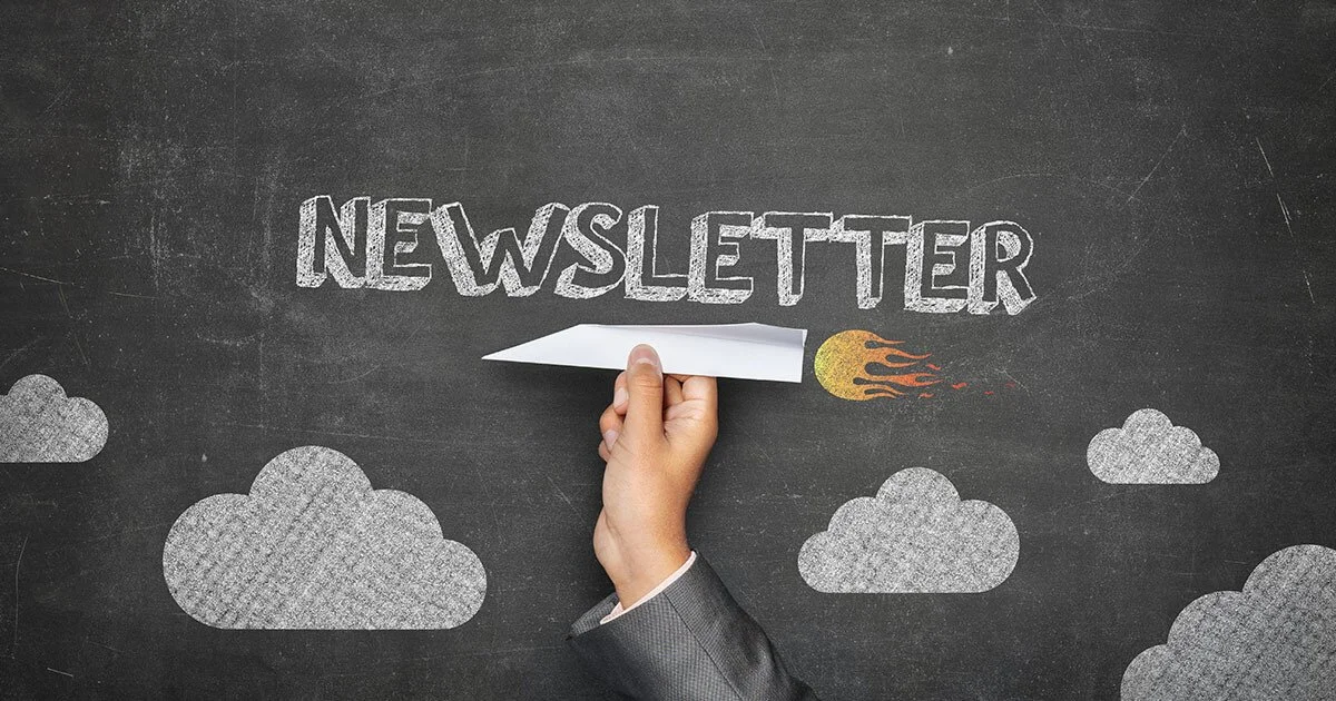 Hand erasing a chalk drawing of the word 'NEWSLETTER' with a paper airplane on a chalkboard background with clouds and a fireball.