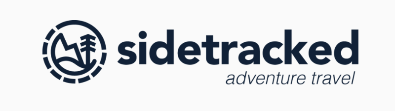 Sidetracked Adventure Travel logo with a circular icon of a mountain, tree, and trail outline.