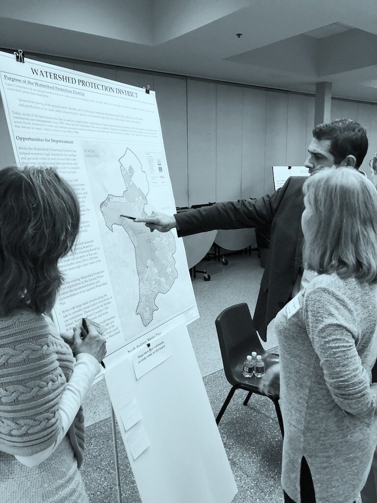 Man points and speaks about map with two women at a community planning workshop - JM Goldson (Copy)