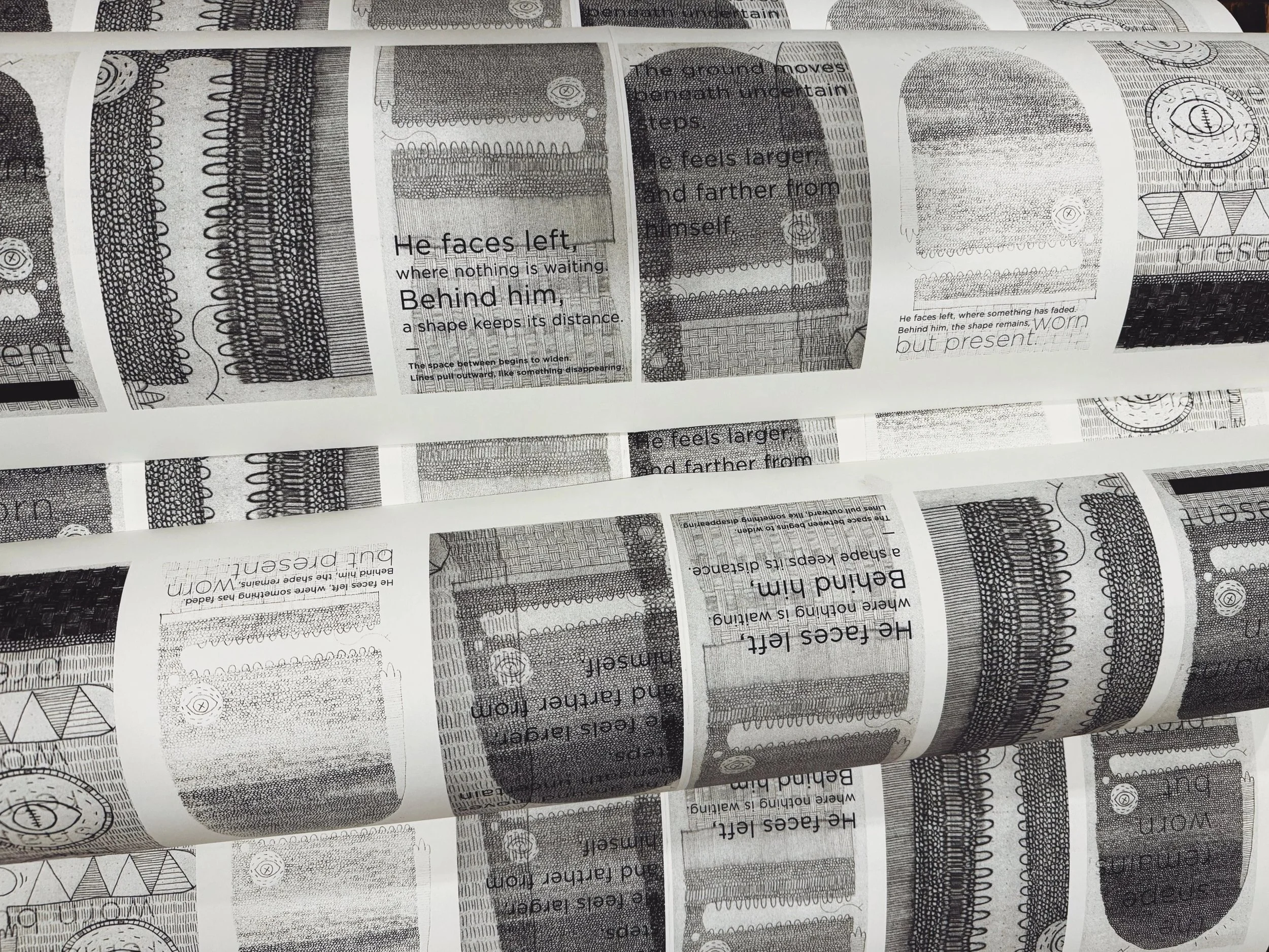 Close-up of a roll of paper with black and white printing, featuring various abstract patterns, lines, and text.