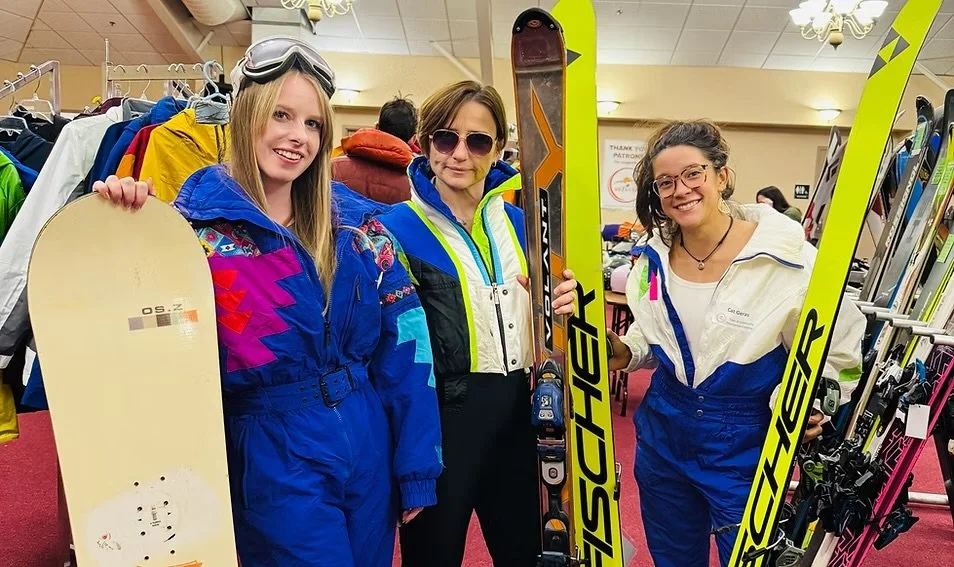 ladies wearing skiing gear and holding their boards
