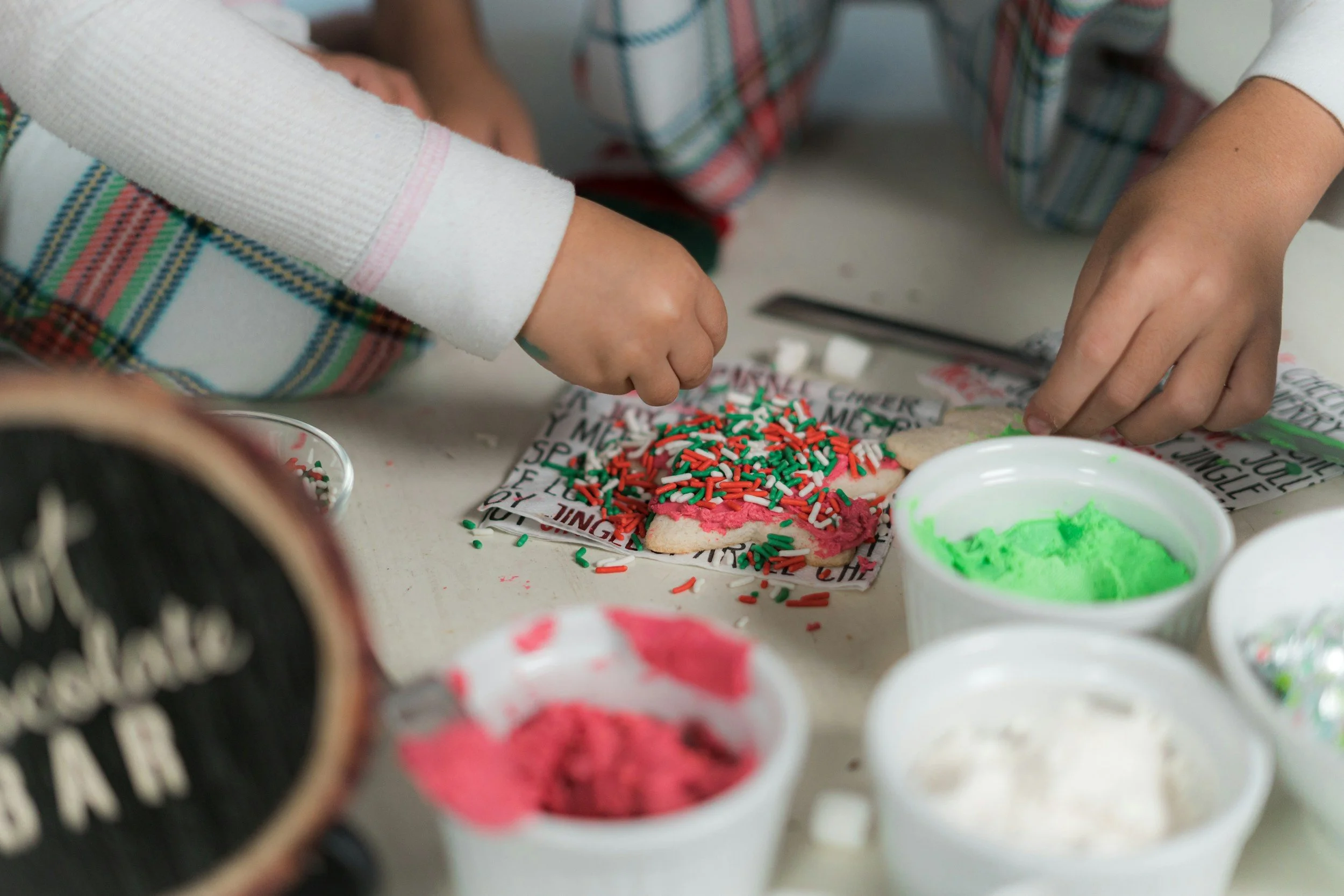 Kids putting sprinkles on cookie