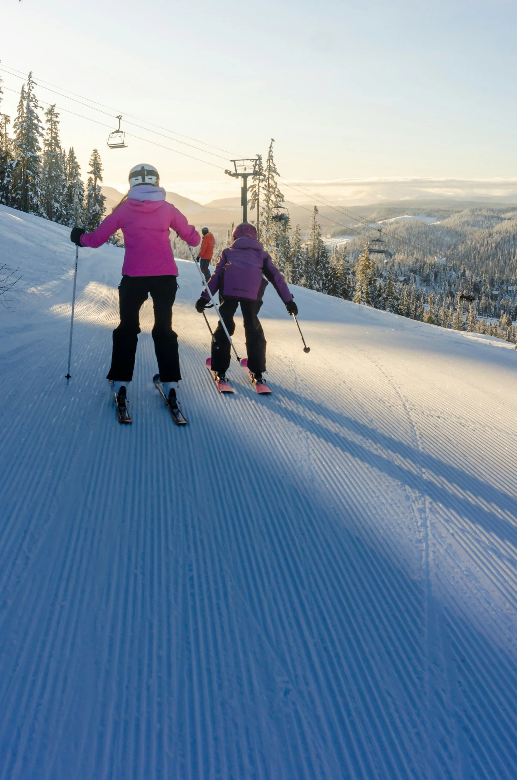 Kids skiing with gondalas overhead