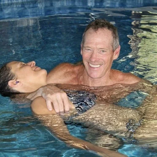 Man holding a woman afloat in the water