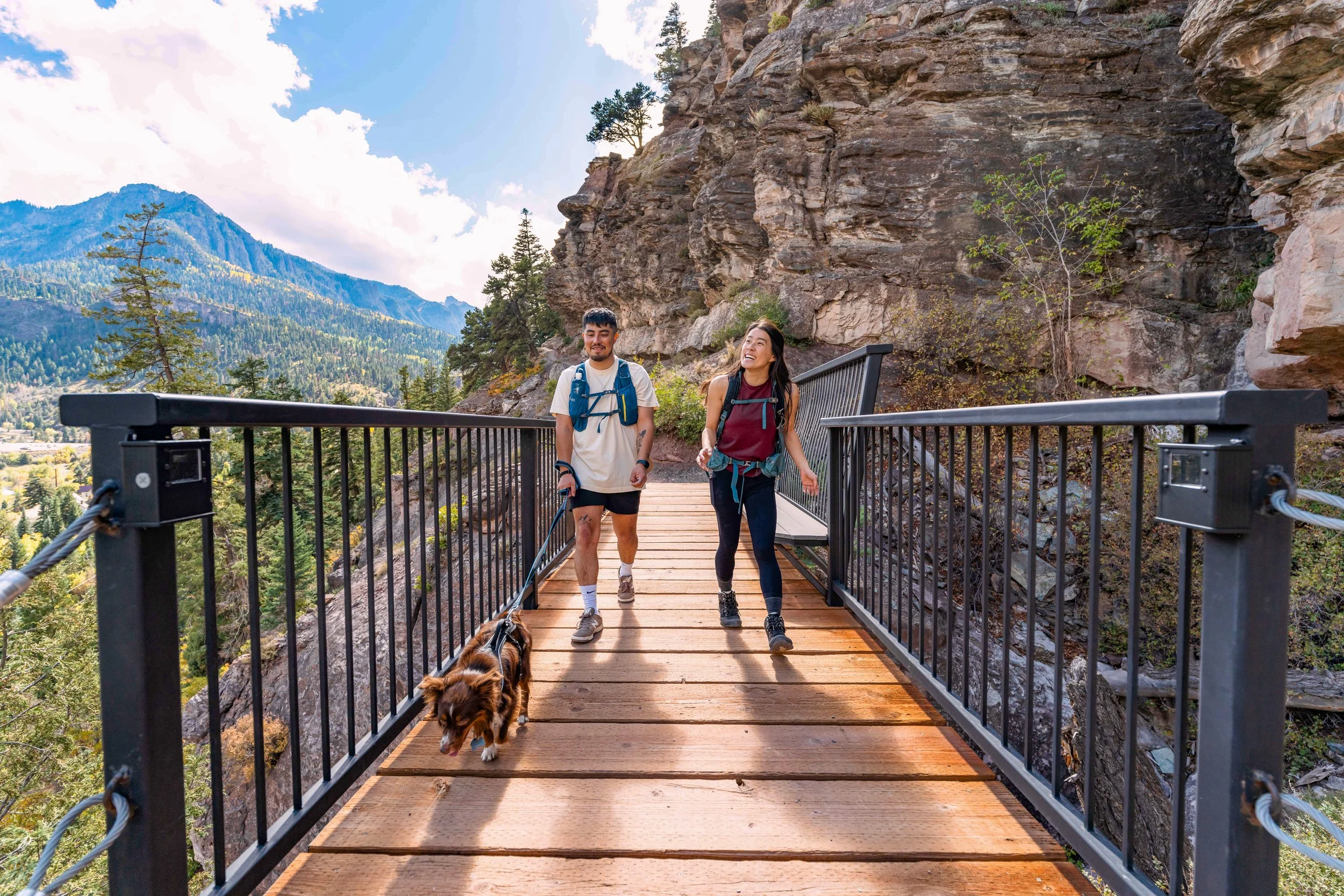 Two people hiking with dog on perimeter trail
