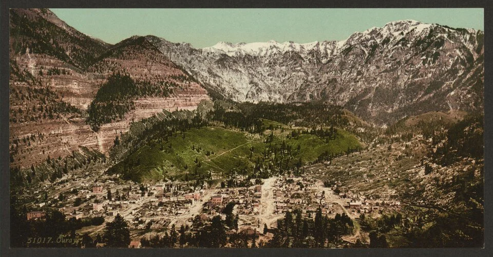 Historic view of Ouray Colorado surrounded by steep San Juan Mountain peaks