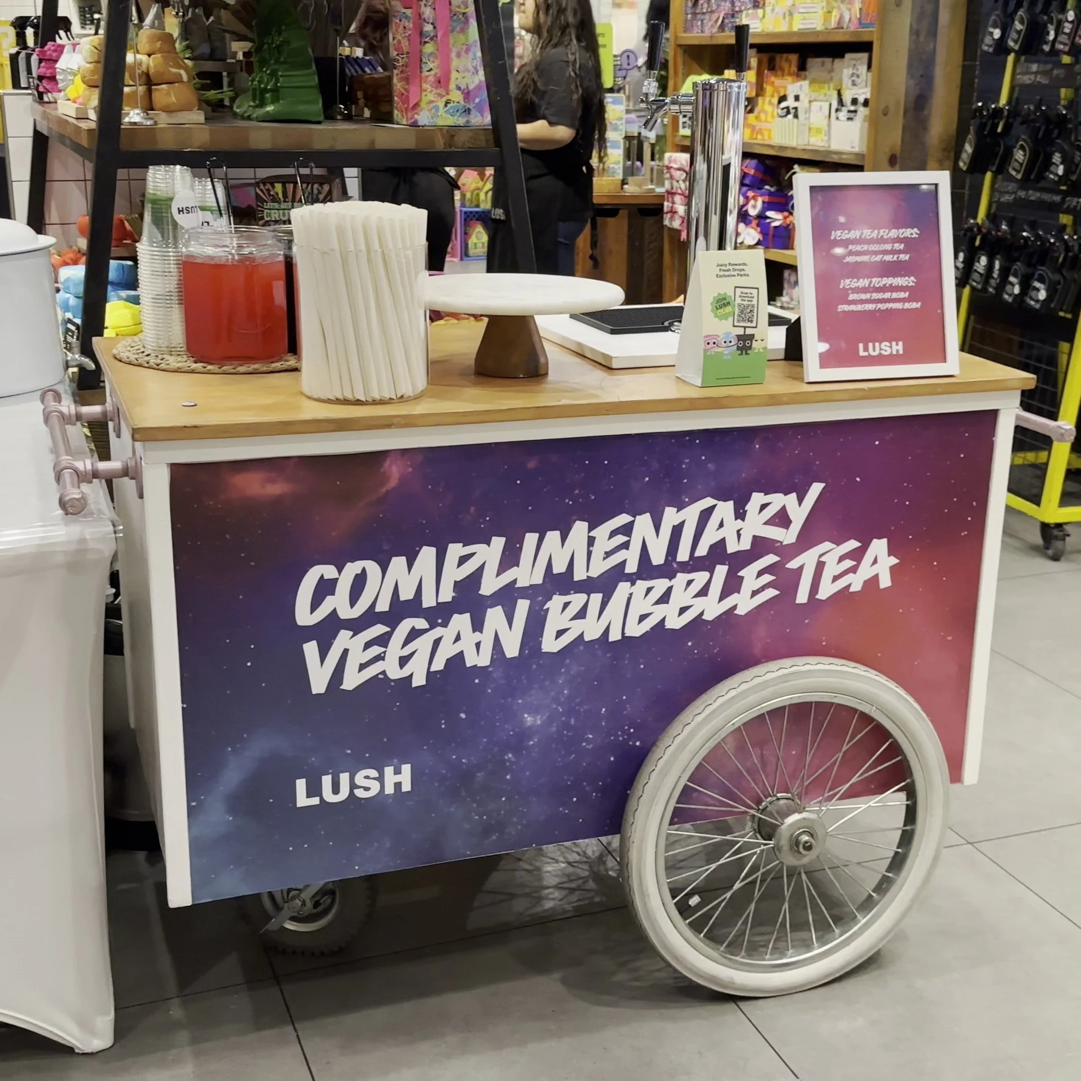 The Jolly Sheep boba catering cart with a custom vinyl for Lush cosmetics that says "Complimentary vegan bubble tea"