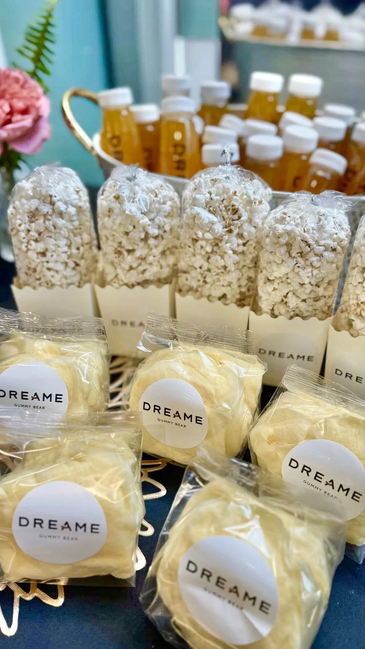 mini cotton candy bag favors on a table along with popcorn box favors in the background