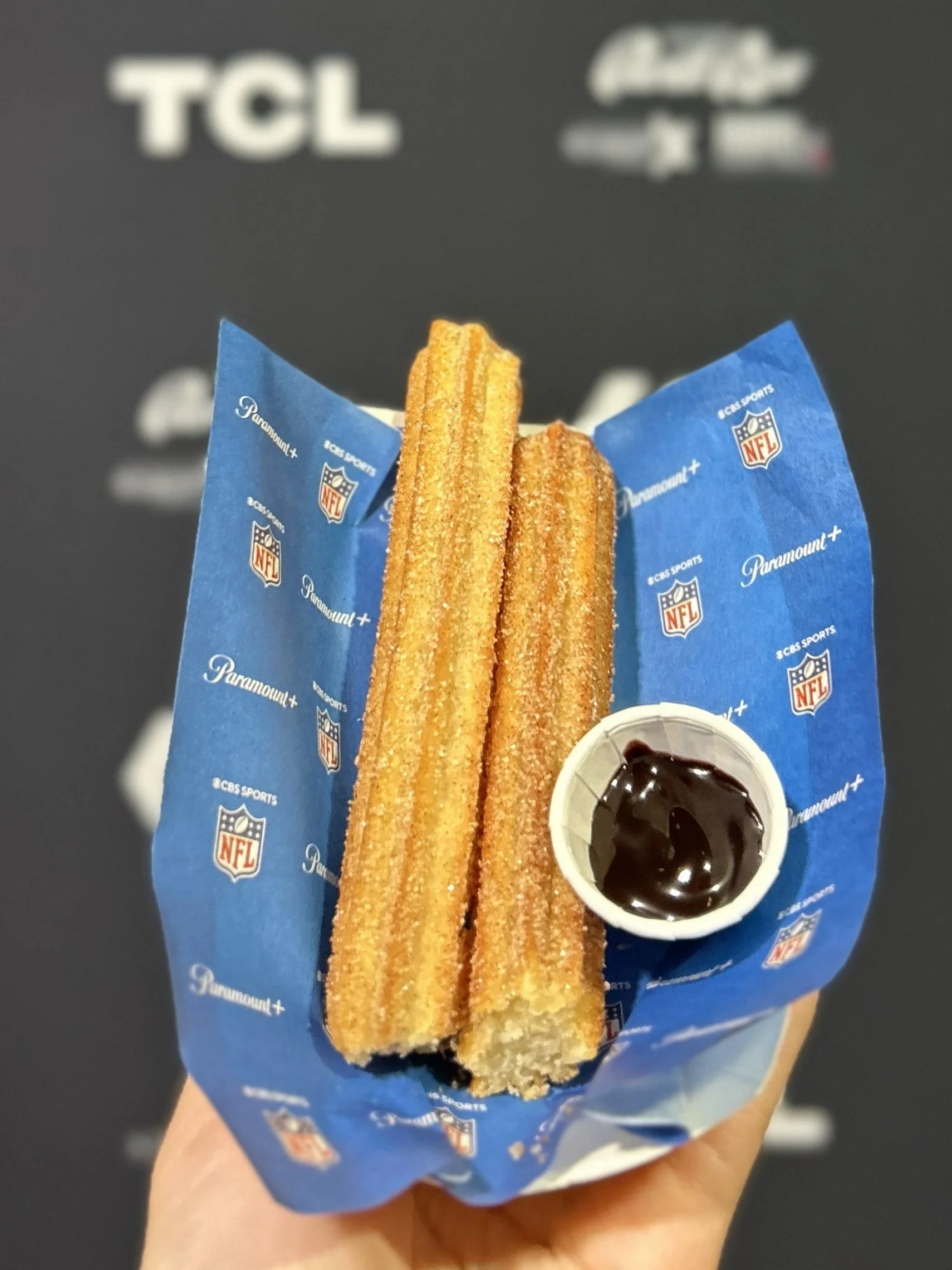 Custom branded food paper with the paramount plus logo beneath a serving of churros and a chocolate dip cup for a brand activation