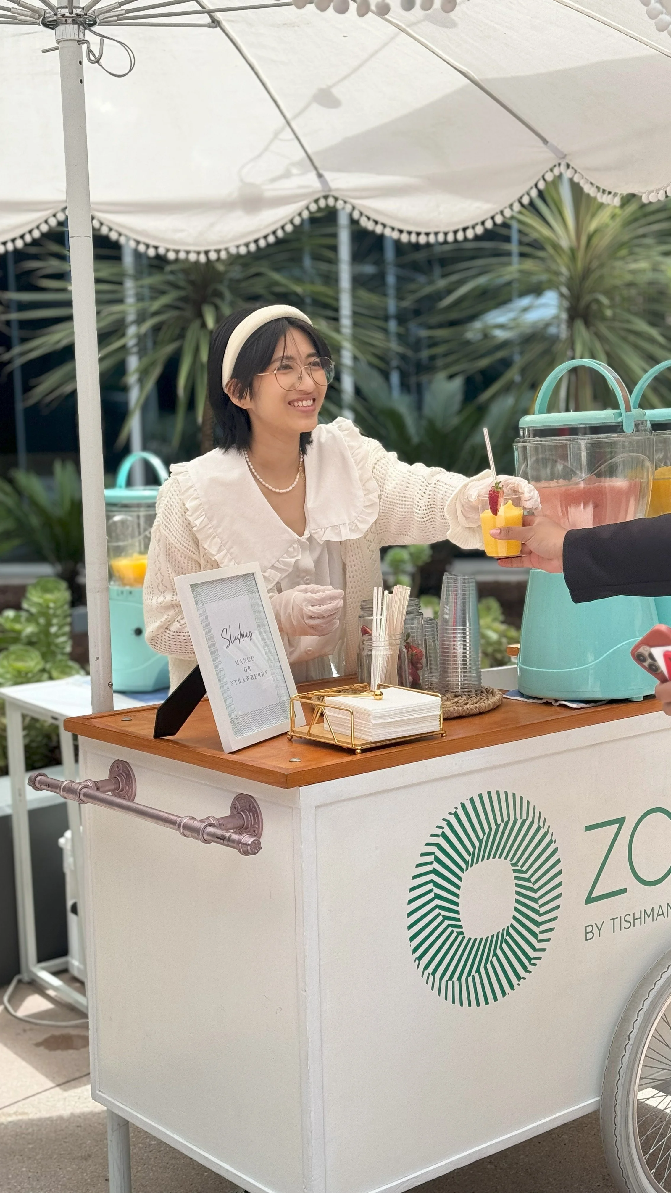a jolly sheep attendant at a slushie cart happily serving a client