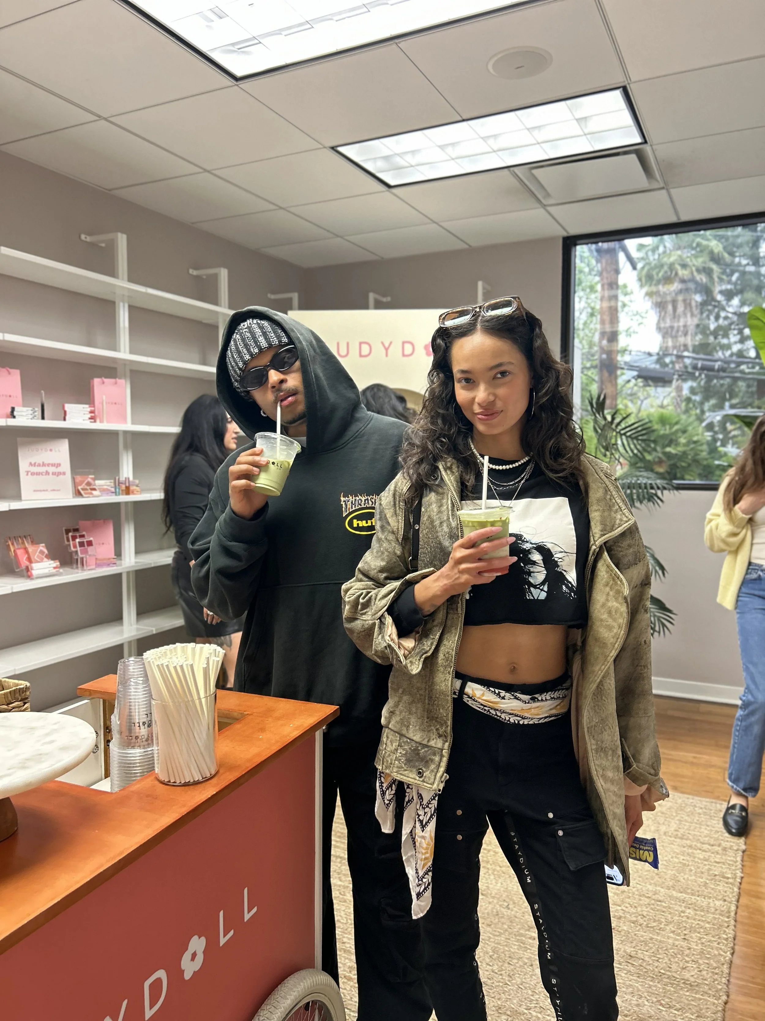 two people holding custom JUDYDOLL matcha drinks at a PR event
