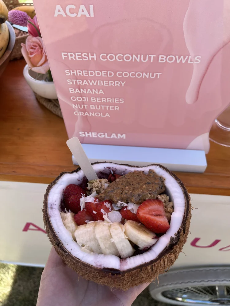 A split coconut shell as an acai bowl with banana and strawberry toppings, served by The Jolly Sheep for a Sheglam event.