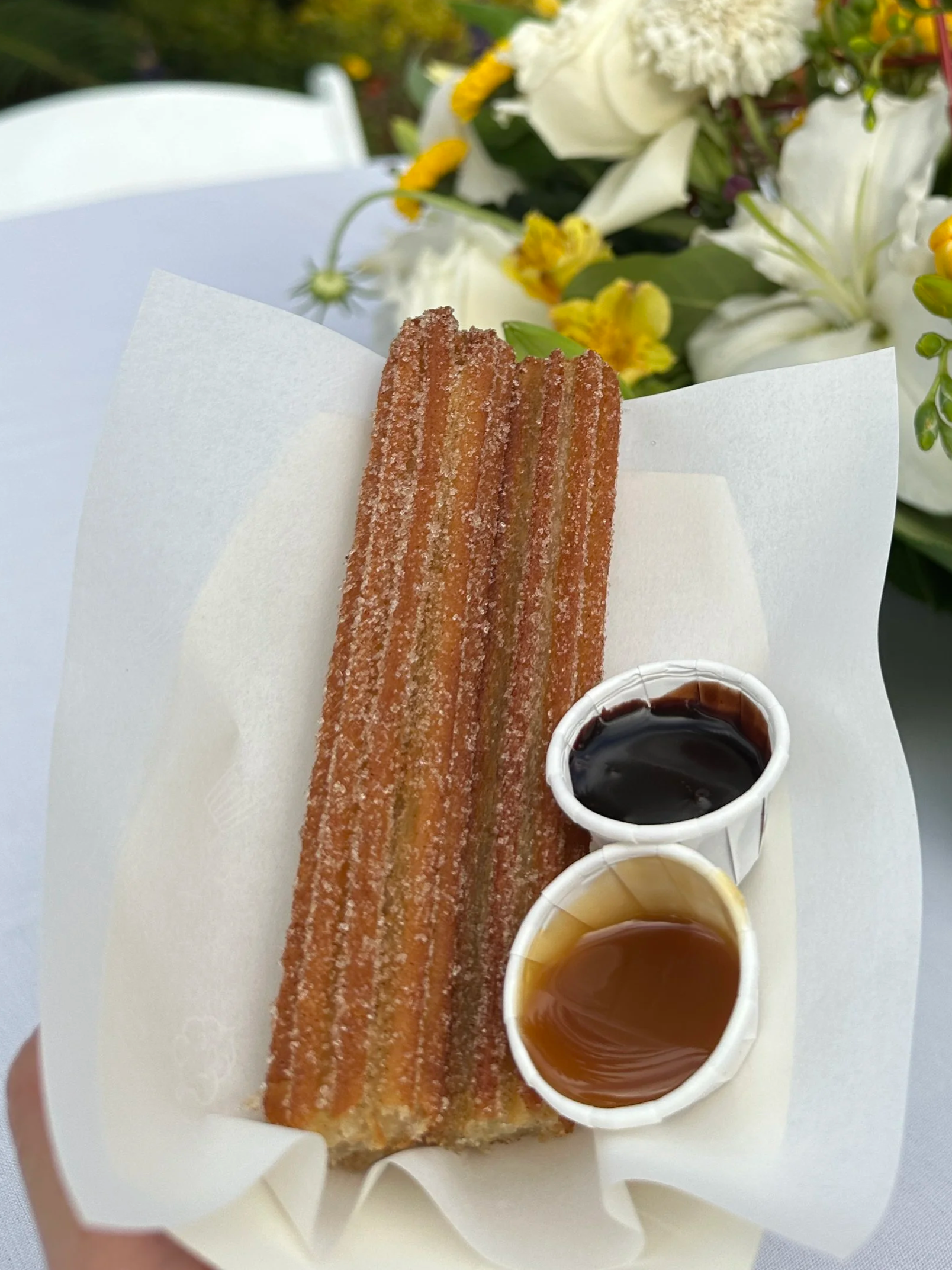 A tray of half cut churros with chocolate and caramel dip cups