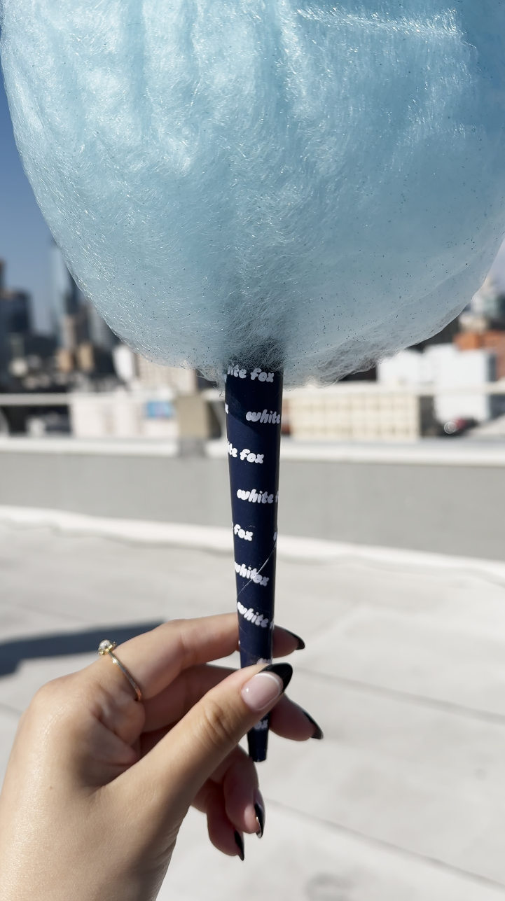 a close up of a cotton candy cone customized with the white fox logo in a repeating pattern