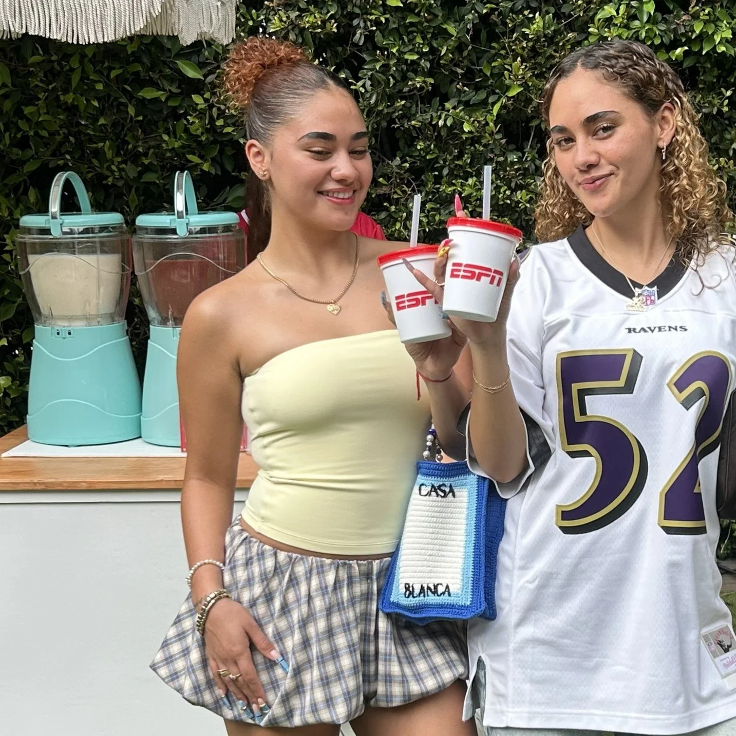 two girls holding up slushy cups at an ESPN branded event