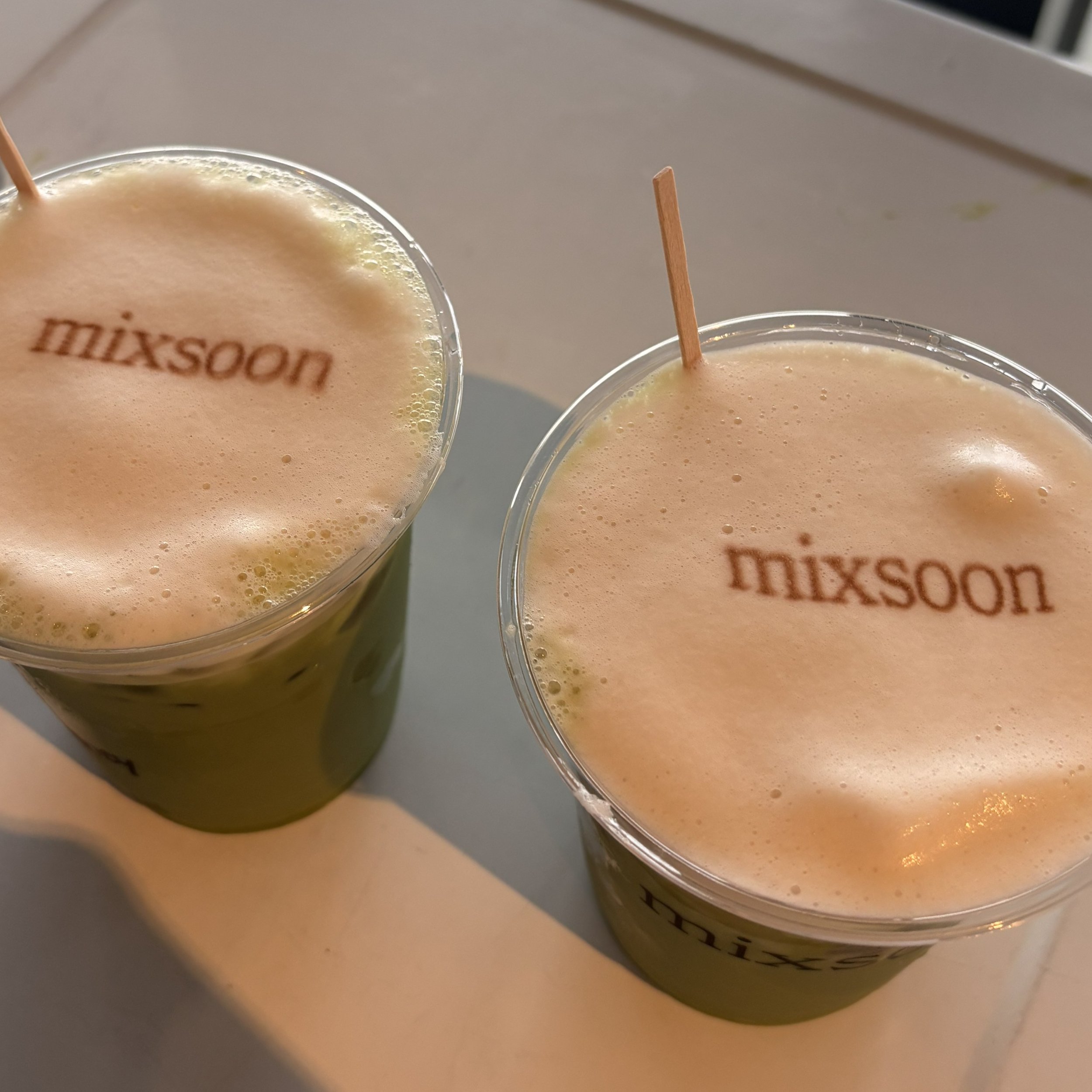 two matcha drinks with edible custom prints that say mixsoon