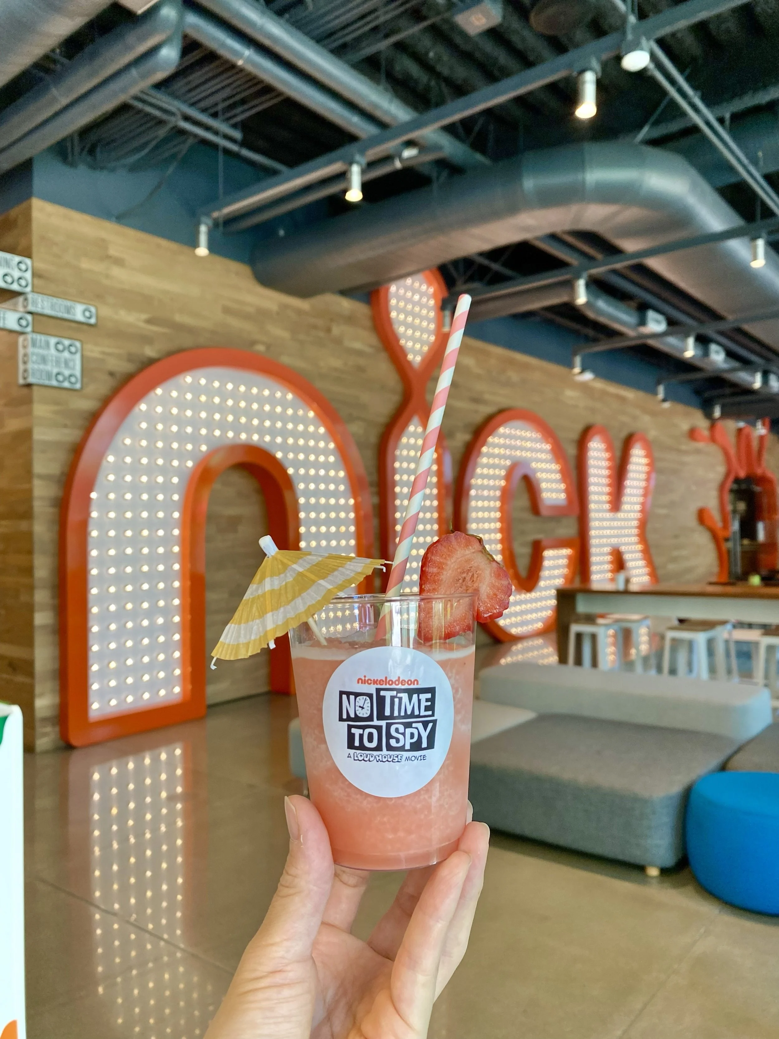 Garnished strawberry slushie with striped straw and mini umbrella at a Nickelodeon corporate event