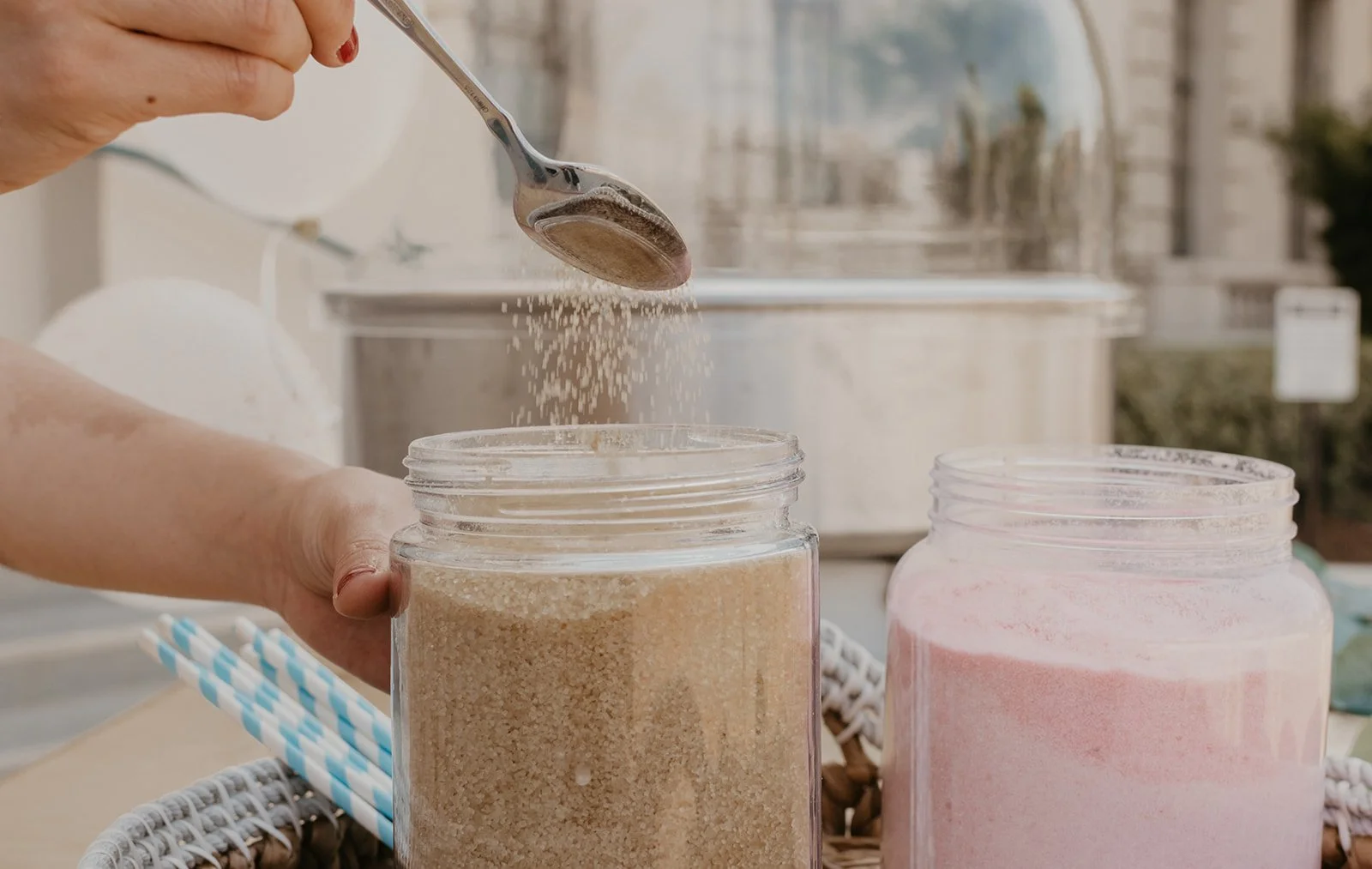 sugar falling gracefully from a spoon into a jar full of cotton candy sugar