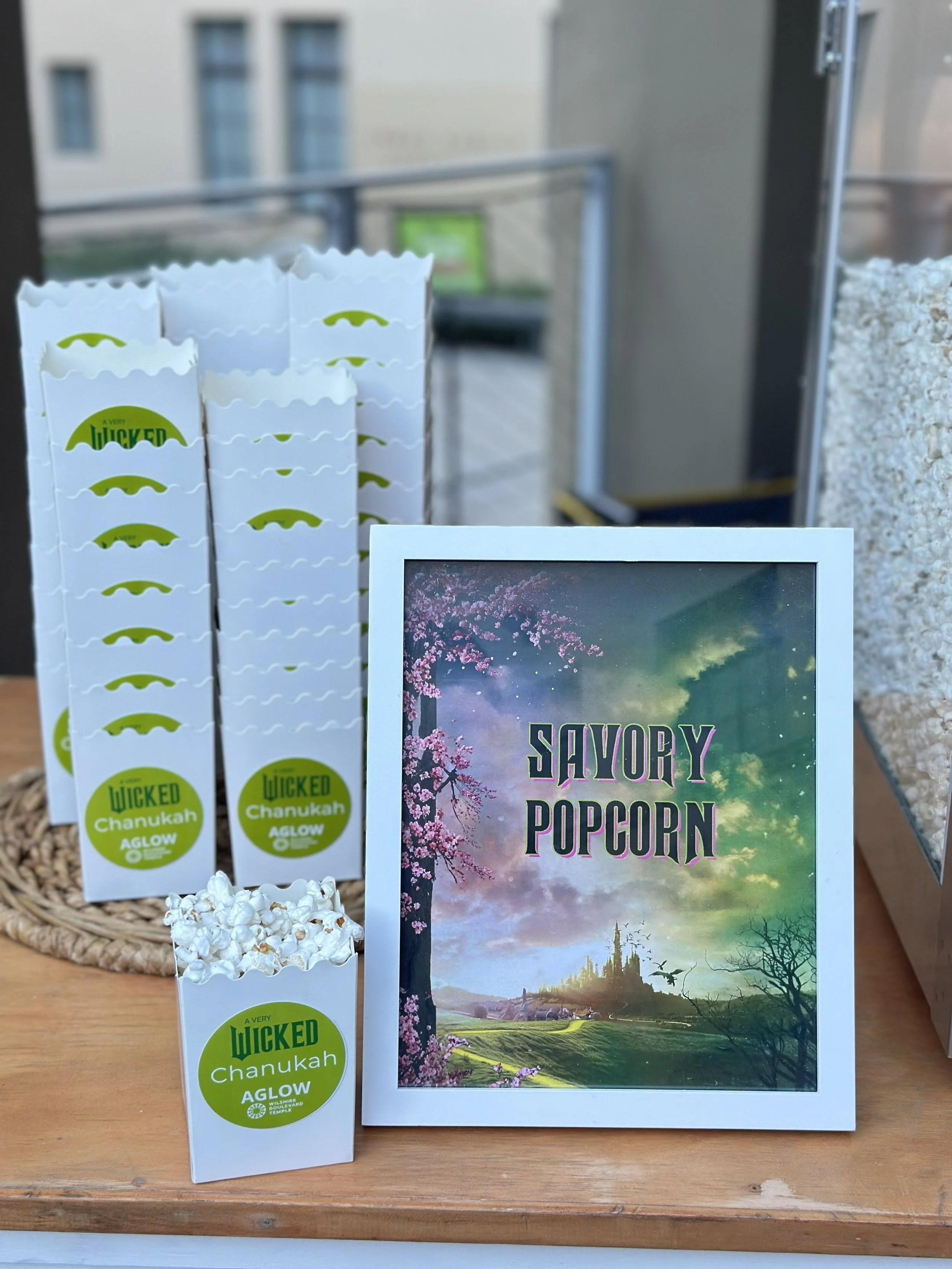 white popcorn boxes with a round custom label sitting next to a menu of similar design